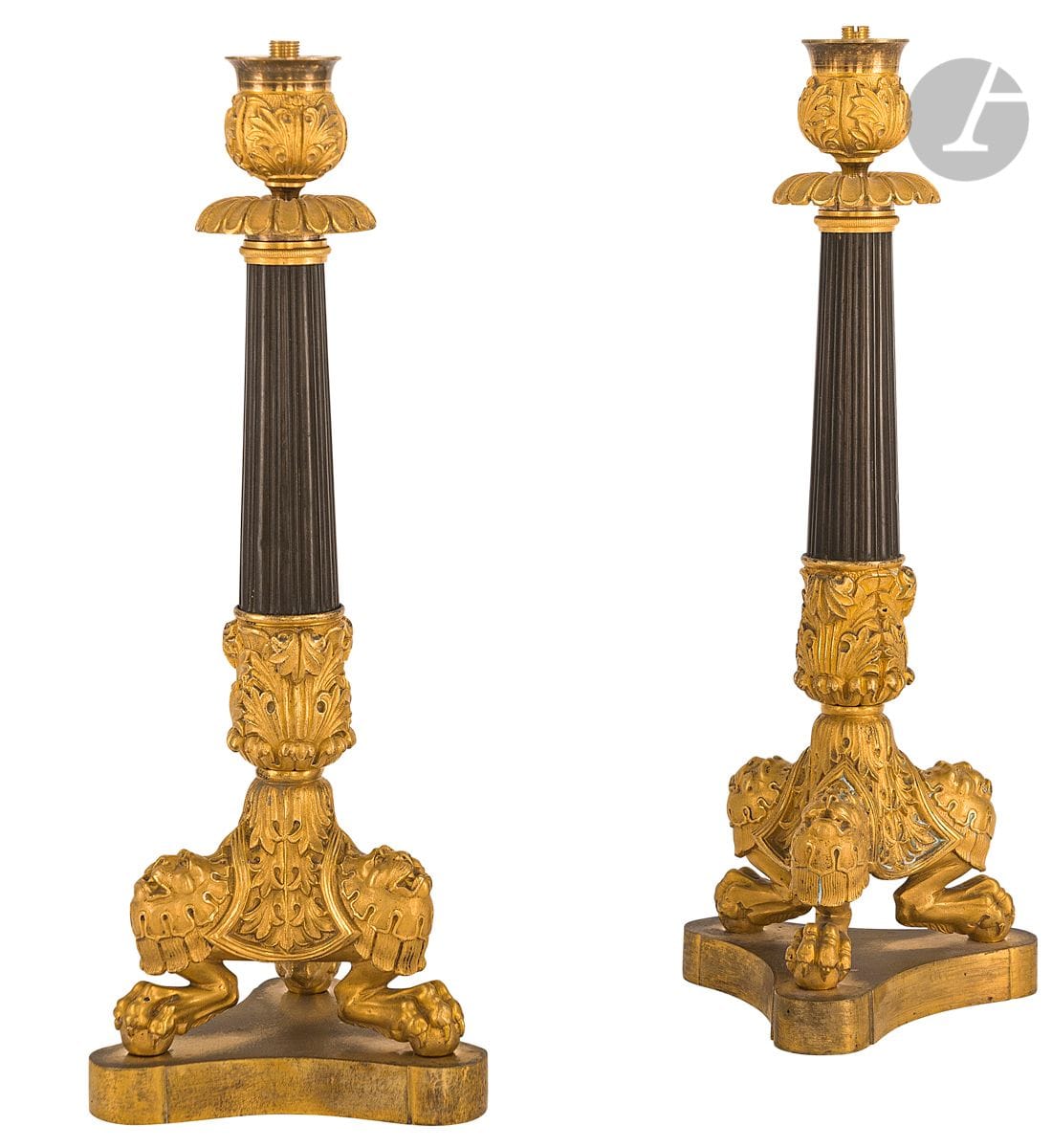 A pair of patinated and gilt bronze torches, the shaft with flutes resting on a base decorated with stylized foliage, lioness's head and claw feet; (mounted as a lamp).
Middle of the 19th century.
H : 32 cm

