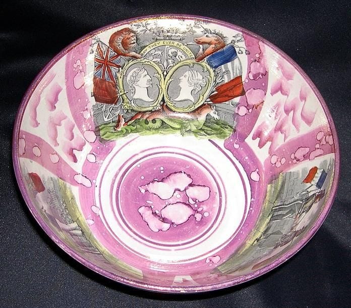 Grand bol en faïence fine à décor imprimé et peint sur fond irisé rose. L'extérieur est décoré de trois panneaux, l'un représente un tableau de loge avec au centre des deux colonnes le Temple de Salomon, sur les cotés les trois vertus et les outils, le second représente un trois mats dénommé " Northumberland 74 ", et le troisième une maxime sur la vie. L'intérieur est aussi orné de trois panneaux se rapportant à l'alliance franco-britannique, un panneau représente deux fantassins avec leur drapeau national qui se serrent la main, le second représente la même scène mais avec deux marins. Le troisième cartouche représente en médaillon Napoléon III et la reine Victoria, les étendards nationaux avec et la formule " May they ever be united ". Angleterre vers 1855. Rare (diam. 25 cm. haut. 12,5 cm). Ce bol commémore l'alliance entre Napoléon III et de la reine Victoria contre la Russie qui débuta par la guerre de Crimée en 1853