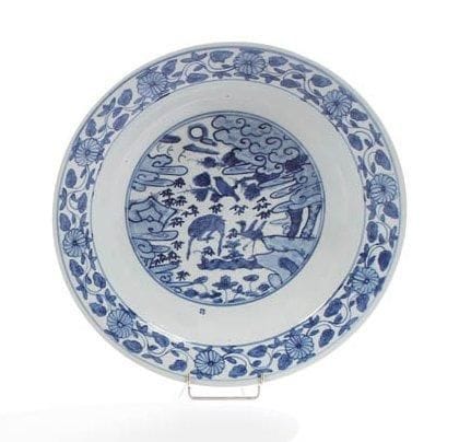 Céramique de la Chine, époque MING (1368-1644) Coupe ronde en porcelaine blanche décorée en bleu sous couverte d'un médaillon de cerf, grue et oiseau sous les nuages. Swatow, XVIe siècle. D.: 42,5 cm