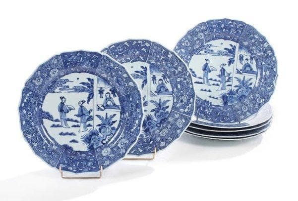 Céramique de la Chine, époque YONGZHENG (1723-1735) Sept assiettes lobées en porcelaine blanche décorée en bleu sous couverte d'un médaillon de deux jeunes femmes sur une terrasse. D.: 28,5 cm