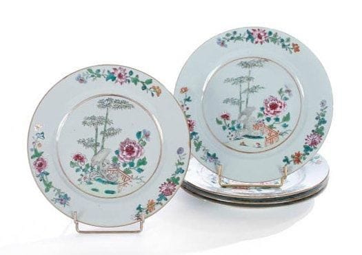 Chine, XVIIIe siècle
Ensemble de cinq assiettes en porcelaine blanche décorée en émaux polychromes de la famille rose d'une terrasse fleurie de pivoines et bambou. Une avec fêlure et ébréchures