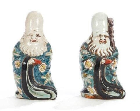 Céramique du Japon, XIXe siècle Deux statuettes de Fukurukuju debout en porcelaine émaillée vert, rouge et jaune, l'un tenant une canne. Au revers de la base la marque Kutani. H.: 13 cm