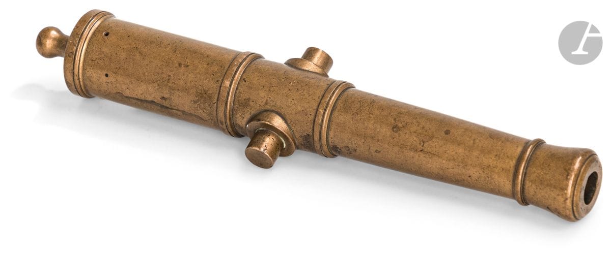 Tube de maquette de canon évasé à la bouche, en bronze, à deux tourillons et quatre anneaux de renfort. 


Bouchon de culasse rond.


B.E. XXe siècle.


Longueur : 23,5 cm