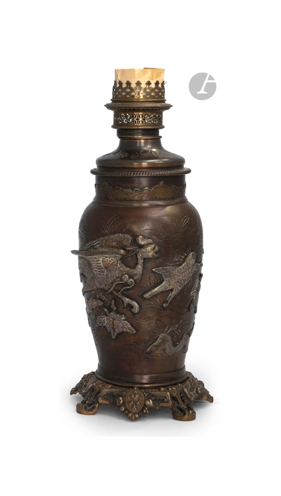 *Vase en bronze monté en lampe, Japon, époque Meiji (1868-1912)
La panse incisée d’un décor de branches fleuries et nuages, et ciselée en haut relief de feuilles de paulownia, d’un Ho-o et de deux moineaux.
Hauteur : 40 cm
Monté en lampe à pétrole puis plus tardivement électrifié.
(Dépatiné)