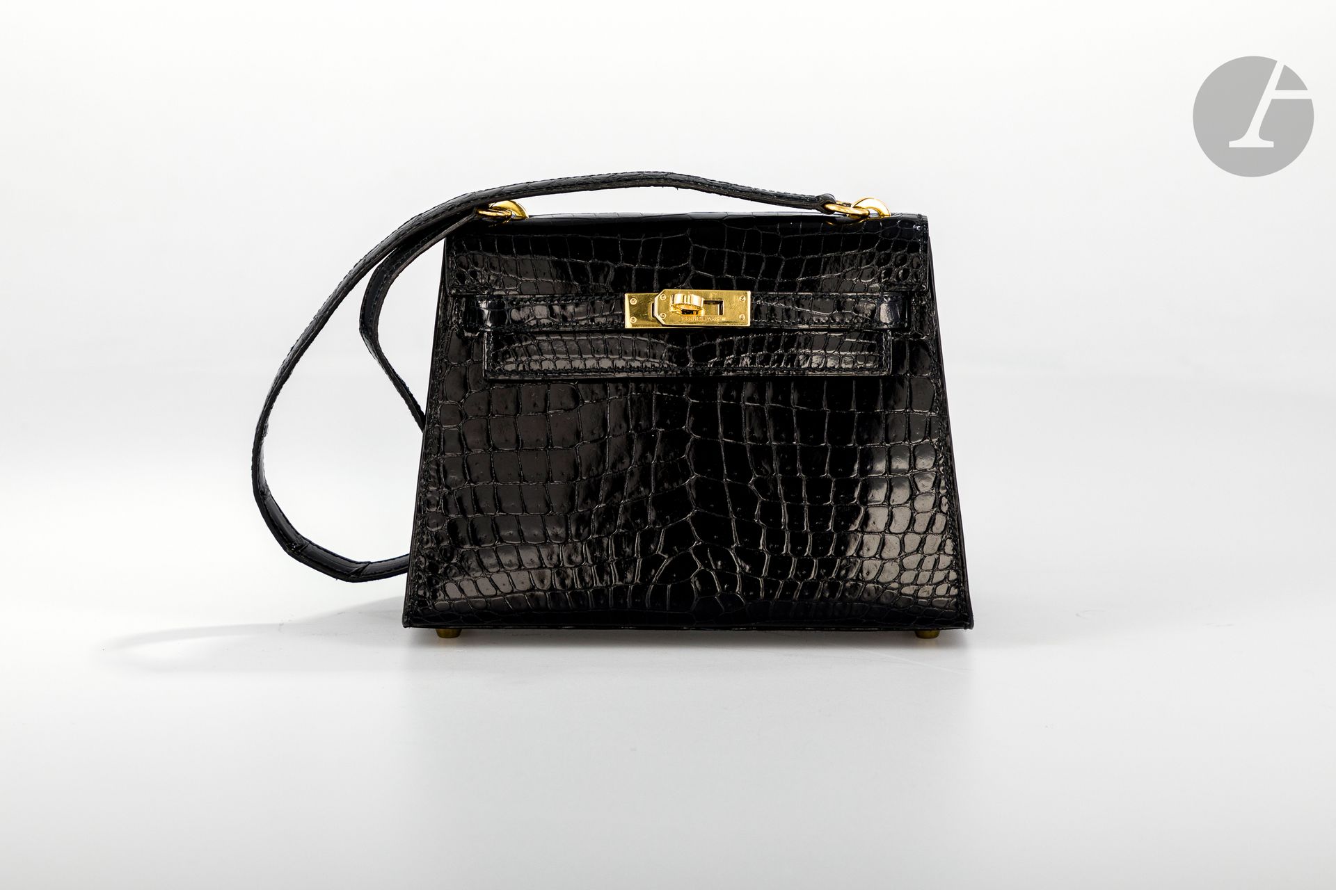 *HERMèS Paris Made in France, circa 1990

Sac Mini Kelly 20 cm en crocodile d’estuaire (crocodylus porosus) noir, garniture en métal doré, bandoulière de 50 cm (très bel état), dans sa housse.