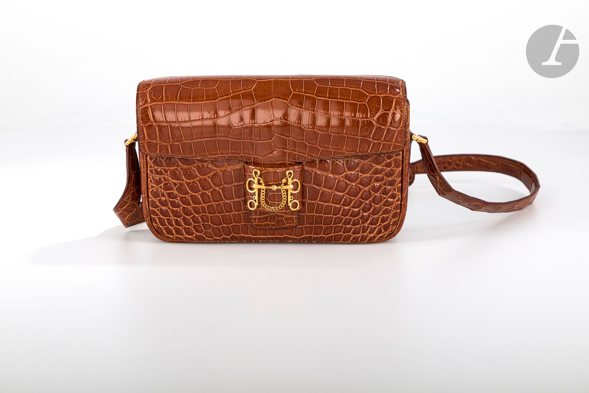 *HERMèS Paris Made in France, circa 1985

Caramel Nile crocodile (crocodylus niloticus) bag, gilded metal trim, shoulder strap, in its cover.

Size : 23 x 15 cm