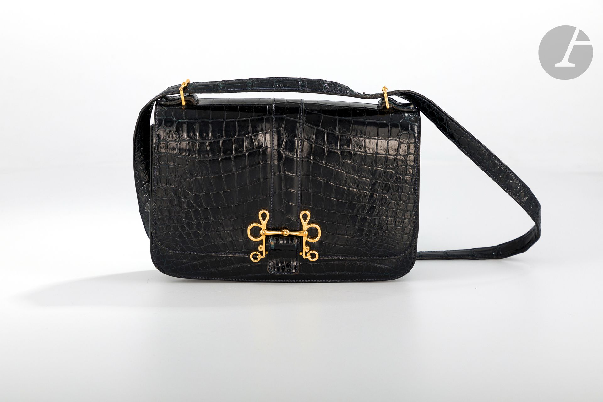 *HERMèS Paris Made in France, circa 1980

Sac Sologne en crocodile d’estuaire (crocodylus porosus) noir, garniture en métal doré, bandoulière (usures au fermoir et aux enchapes), dans sa housse.

Dim : 23 x 16 cm