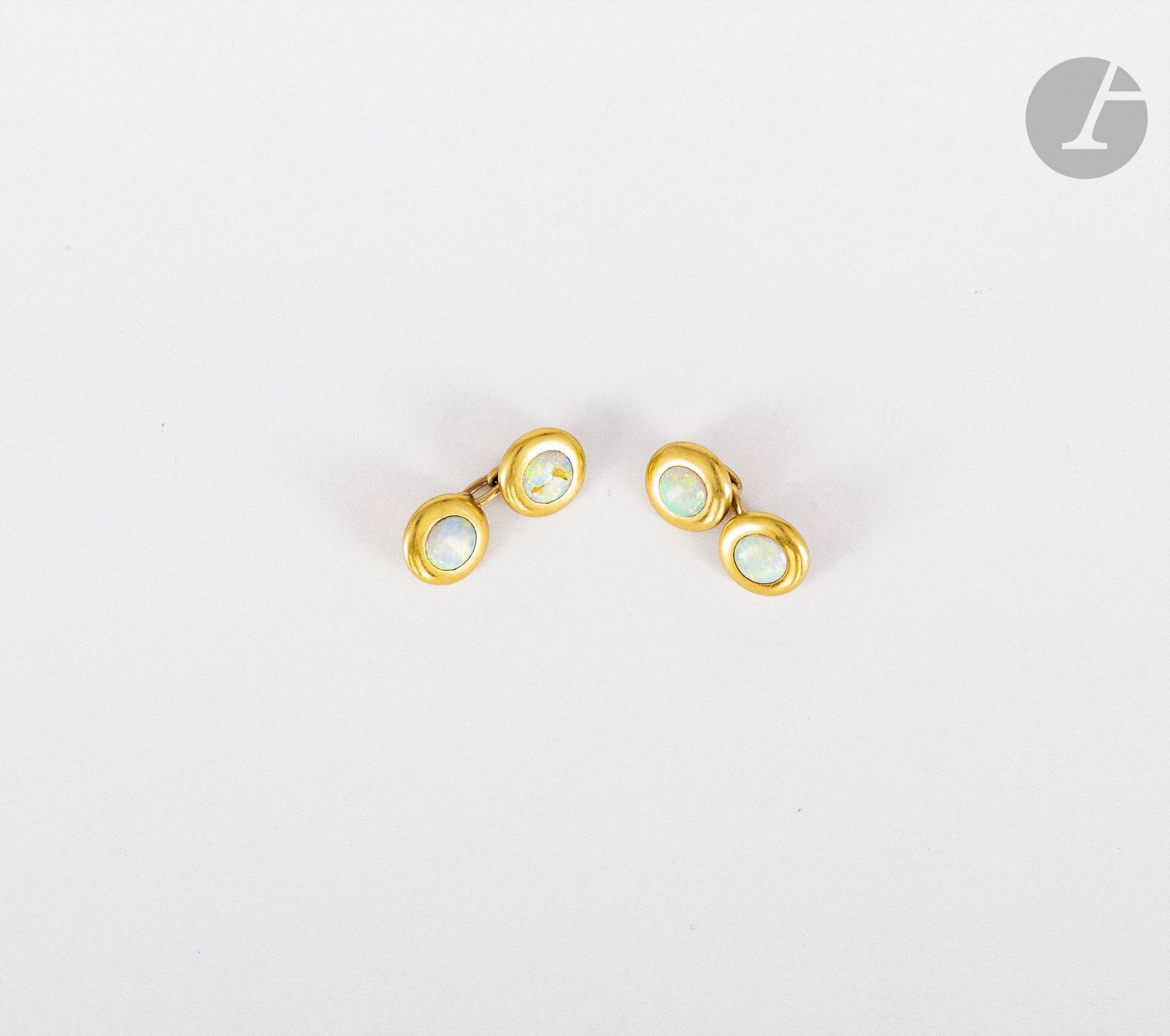 Paire de boutons de manchettes en or 18K (750), ornés d'opales cabochons. Poids brut : 9,4 g (choc)