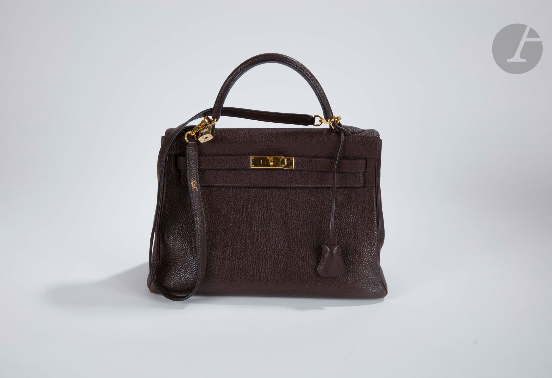 HERMèS Paris Made in France

Brown grained leather 32 Kelly bag, gold metal trim, shoulder strap, padlock, bell, two keys. Year 2006 (slight wear on the corners).