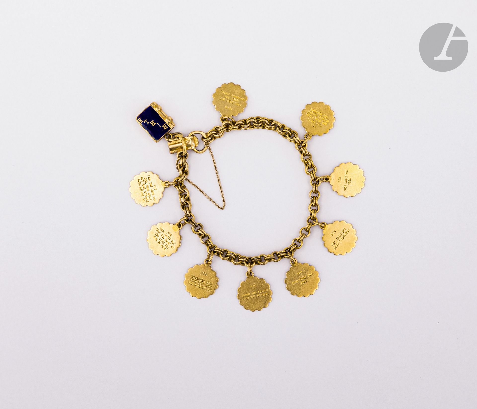 Bracelet en or 18K (750), retenant en pampilles 9 des 10 Commandements (en Anglais) ainsi qu'une Bible. Poids brut : 38,9 g (manque)