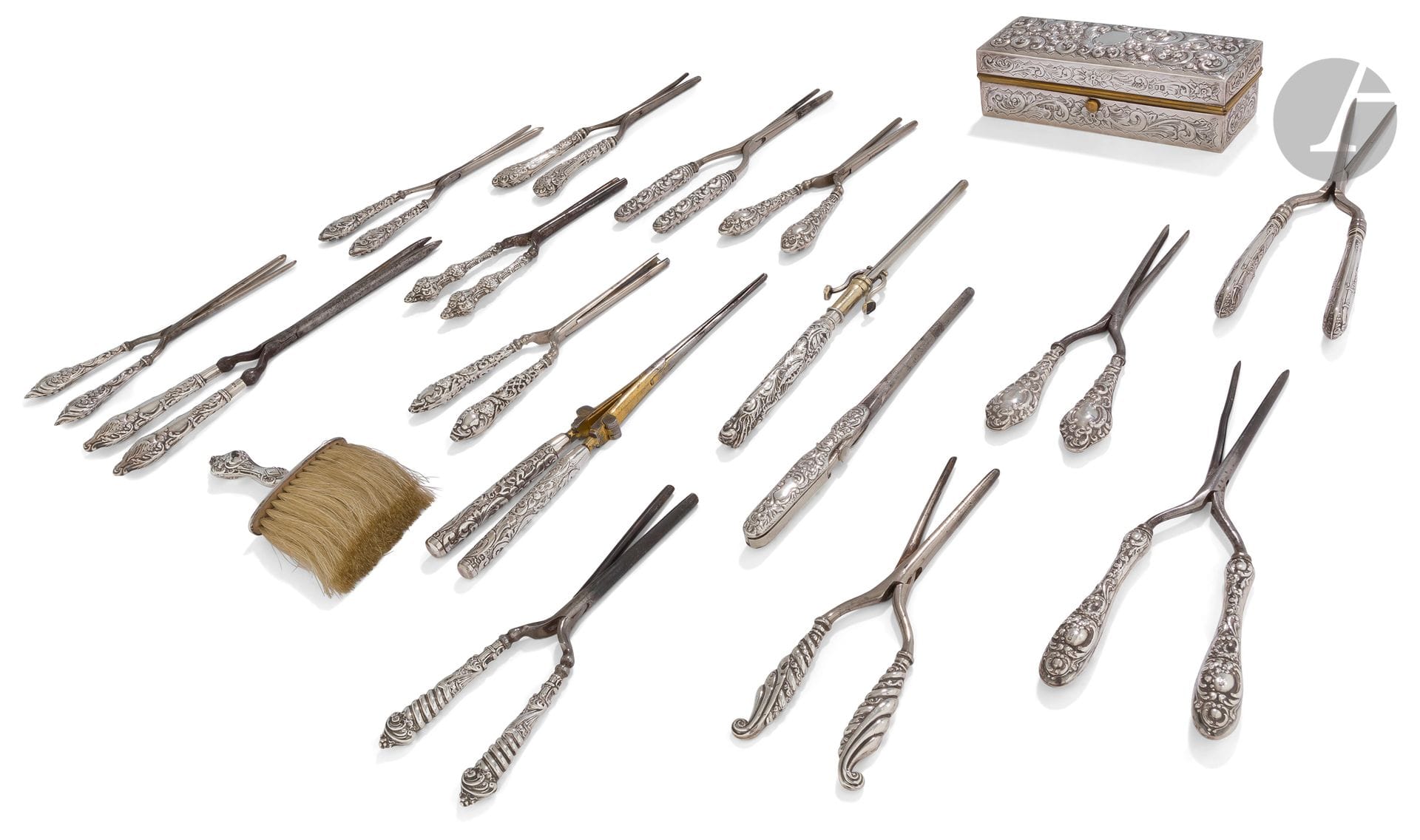 Étonnante collection de seize fers à friser les manches en argent à décor repoussé pour la plupart de motifs feuillagés et enroulements, une boîte rectangulaire à chauffer les fers en laiton recouvert d›argent et une petite brosse en crins et manche argent.
Angleterre, villes de Londres et Birmingham, fin du XIXe, début du XXe siècle (plusieurs lettres-date et différents orfèvres).
Poids brut : 1906 g