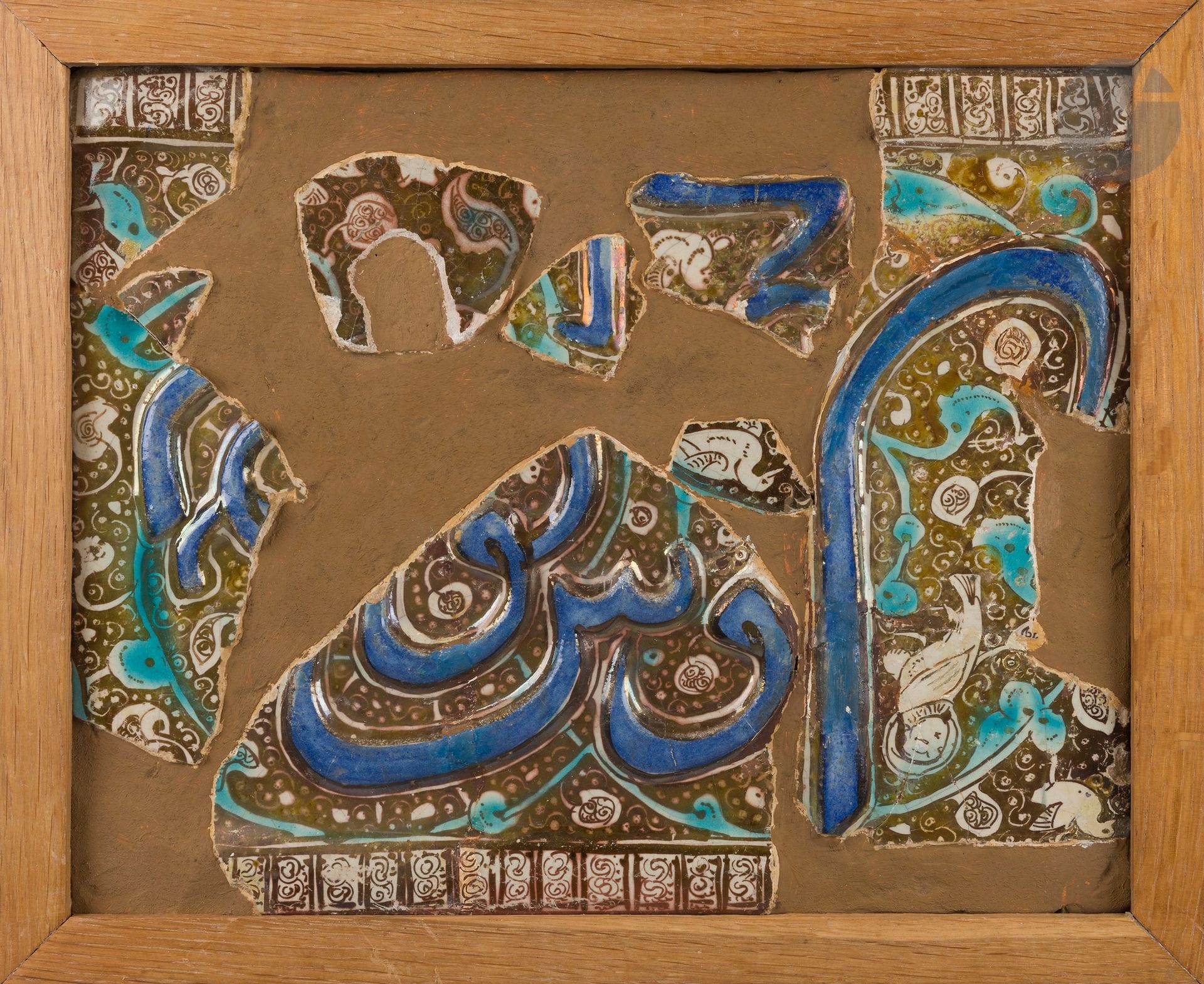 Neuf fragments de carreaux à décor de lustre métallique, Iran ilkhanide, fin XIIIe - début XIVe siècle
Fragments de carreaux à décor épigraphique moulé, rehaussé de cobalt et se détachant sur un fond de décor de lustre métallique peuplé d’oiseaux dans des rinceaux végétaux. Trois présentent une frise géométrique en bordure.
27 x 33,7 cm
Fragments montés dans un enduit encadré.

Ces fragments sont proches stylistiquement des carreaux de revêtement provenant du mausolée du Shaykh Abd al-Samad à Natanz (1308) dont le Musée du Louvre conserve certains exemplaires (AD 7638) sur lesquels la tête des oiseaux a été martelée.

Nine shards of Ilkhanid lustre ware tiles, Iran, late 13th - early 14th century