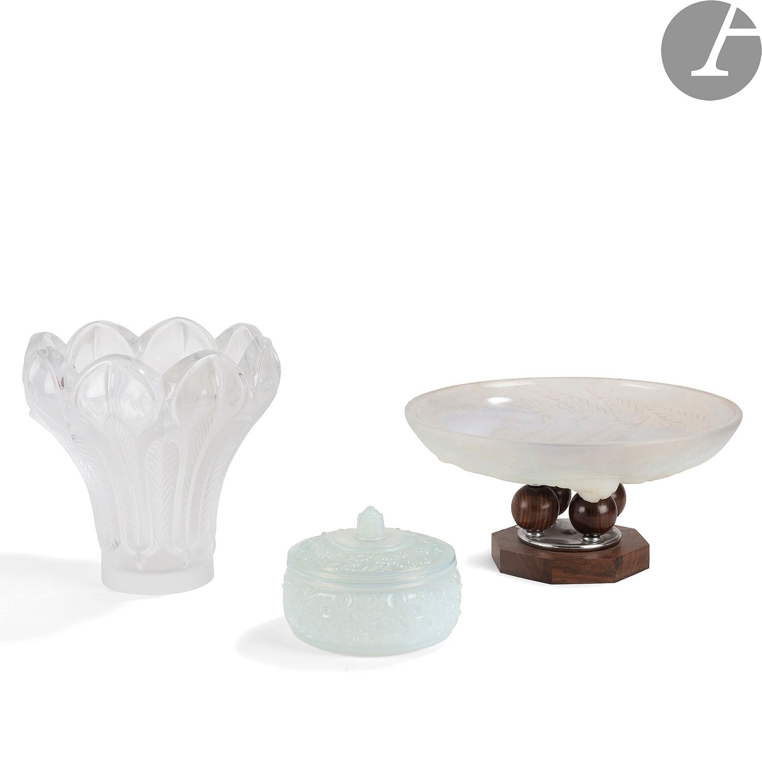 GEORGES TERZIAN COLLECTIONBatch of
glassware : 
- ETLING France. Cup out of moulded-pressed opalescent glass with decoration of ferns resting on a foot formed by three balls in ebony of Macassar received by an octagonal base. H. 14,5 cm 
- LALIQUE France. Vase Esna model out of crystal with decoration of palms. Signed under the base. H. 22 cm 
- SABINO France. Covered pot out of opalescent glass with decoration of flowers. Signed under the base. H. 11 cm



