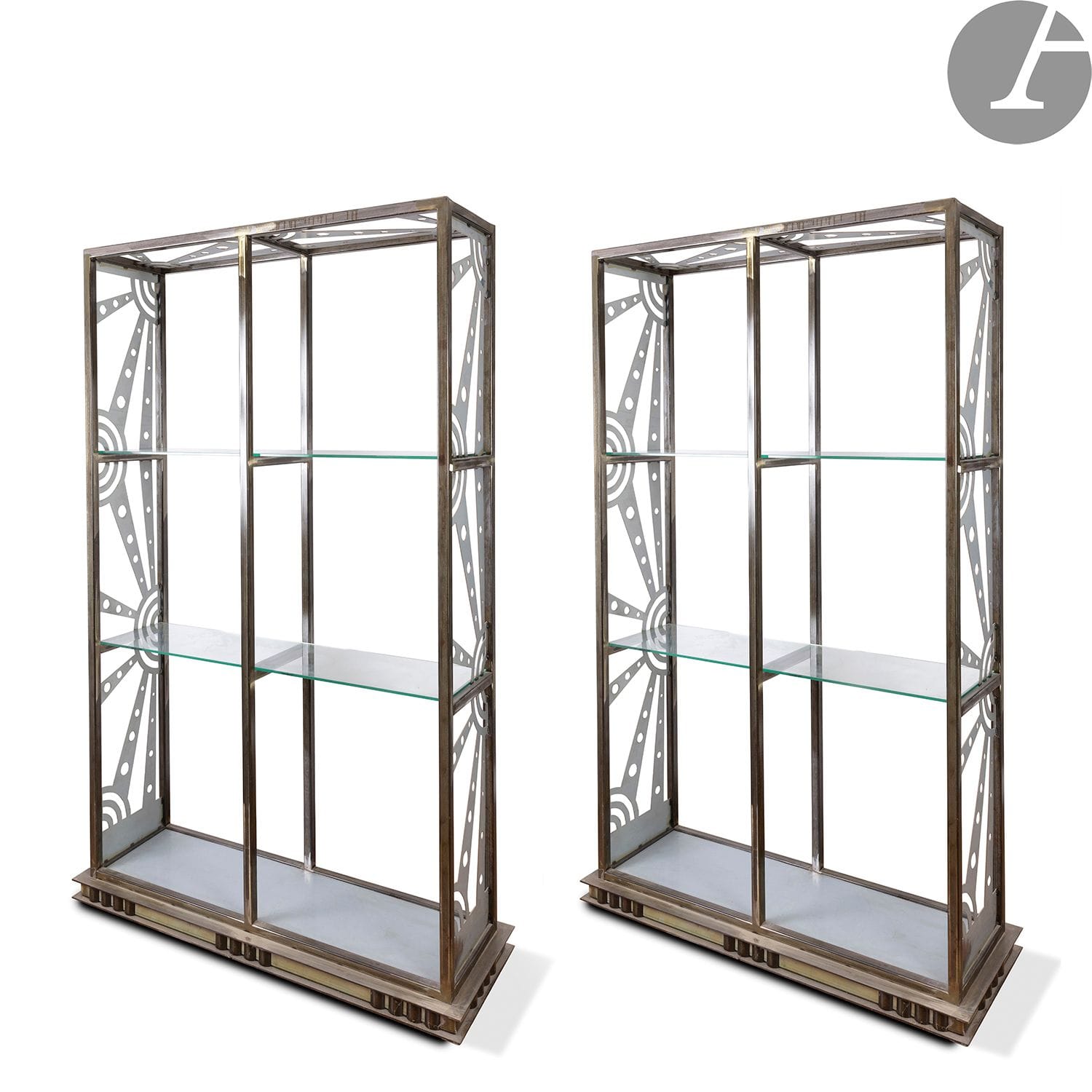 GEORGES TERZIAN (1939-2021)
Paire d'étagères en acier à trois plateaux. Les montants à décor rayonnant ; les tablettes en verre clair. 
H. 200 cm – L. 122 cm