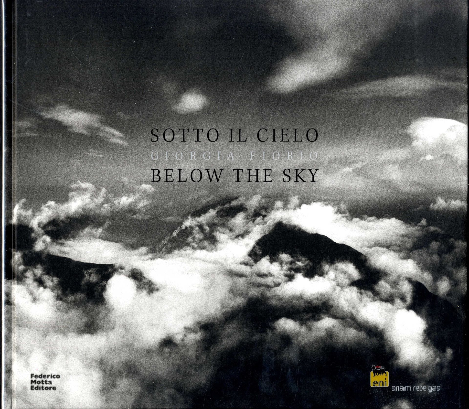FIORIO, Giorgia (née en 1967) [Signed]

Below the Sky ¨ Sotto il cielo.
Milan, Federico Motta Editore - Eni Snam Rete Gas, 2009.

In-4 (31 x 34 cm). Édition originale hors commerce dédicacée sous la forme d’une écriture – dessin représentant la ligne des montagnes et signée par Giorgia Fiorio en page de titre, 180 pp, 102 photographies en noir et blanc en pleine page ou en double page, textes en anglais et en italien de Daniele del Giudice et de Giorgia Fiorio, reliure d’éditeur cartonnée et jaquette transparente titrée, boitier éditorial rigide illustré sur les deux faces.