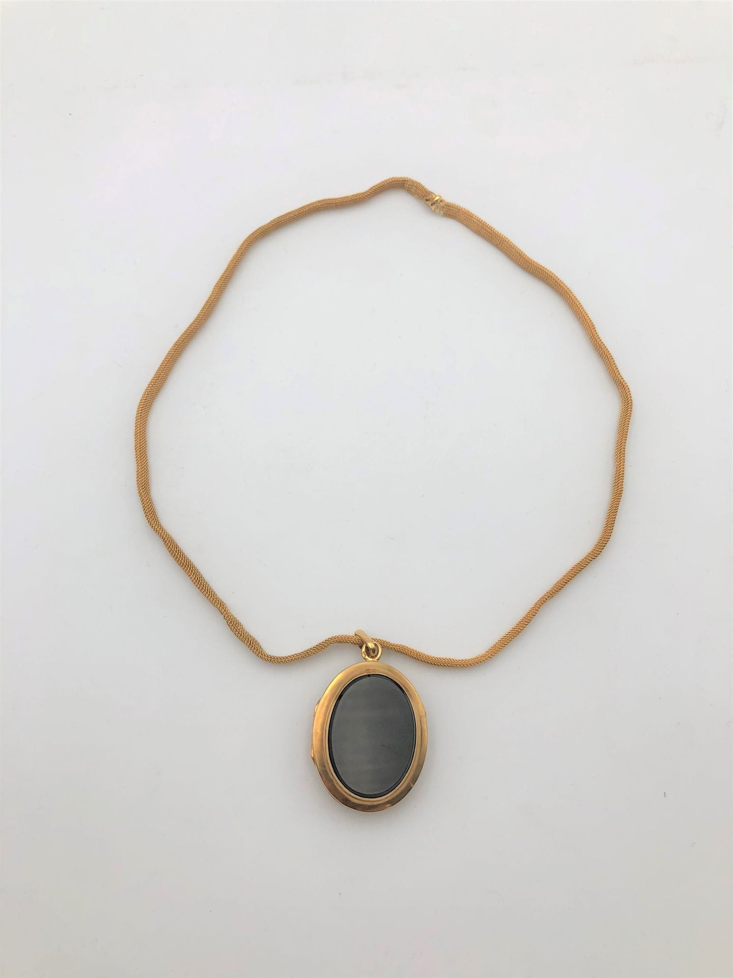 Médaillon porte photos en or (18K) et onyx et ruban en or (18K). Poids brut: 25,9 g
(Poids chaine: 11,8 g - accident)
