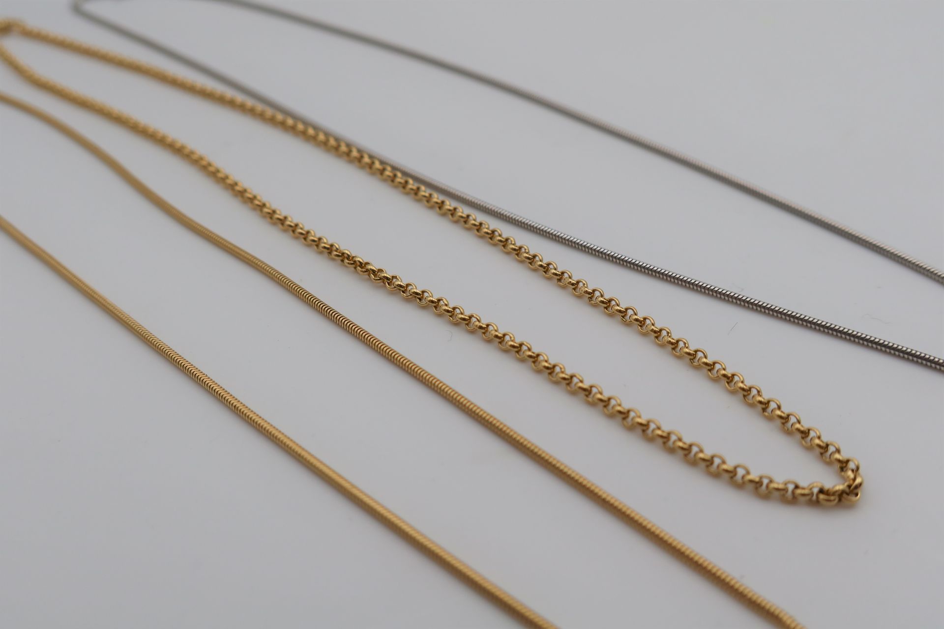 Lot de 3 colliers en or (18K), l'un jaune, l'autre blanc. Poids : 20,2 g