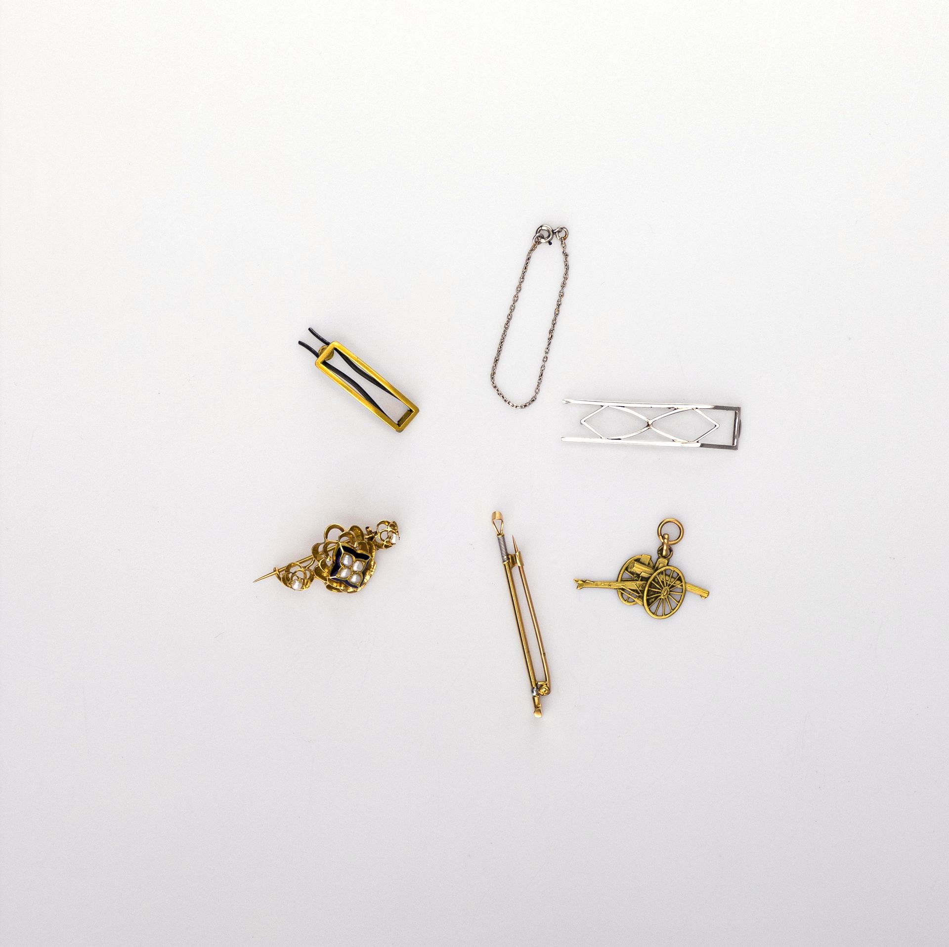 Lot de bijoux et bris en or ou platine. Poids brut: 12,5 g
- 1 broche en or (18K) émail et perles (accident). Poids brut: 3,5 g 
- 1 broche "cravache" et 1 pendentif "canon". Poids: 5, 5 g
- chainette et bris en platine (3,4 g) et or blanc. 
On joint une barette en métal doré


