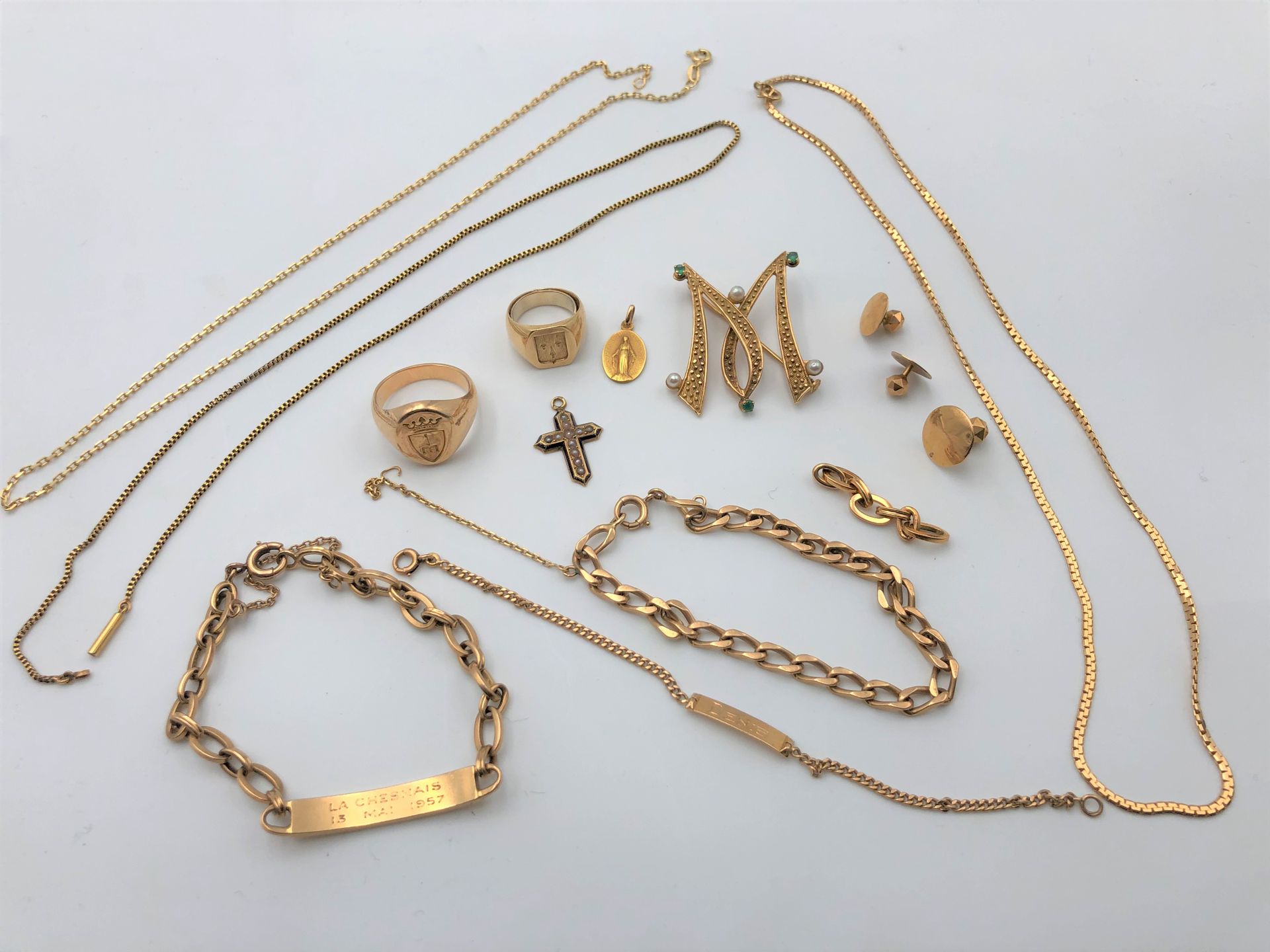 Lot de bijoux en or (18K). Poids brut : 79,7 g
2 chevalières, 3 boutons de col, 2 gourmettes, bracelet souple maille gourmette, 2 collier chaines, 1 pendentif croix émaillé et permettes, 1 broche M avec pierres vertes et perles.