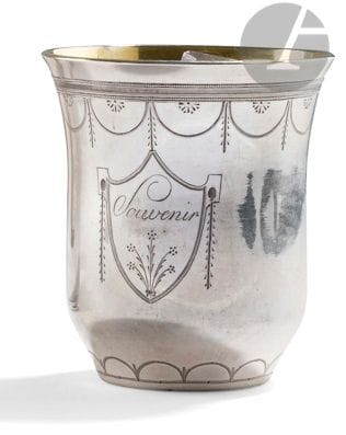 EASTERN EUROPE XIXth CENTURY
Silver tumbler, the interior in vermeil, the base engraved with a decoration of arcatures in lozenges, the edge of the neck of a motive of draperies under a row of pearls. The body is engraved Souvenir à l'anglaise in a shield underlined by a flowery bouquet.
Weight : 149 g - height : 8,3 cm