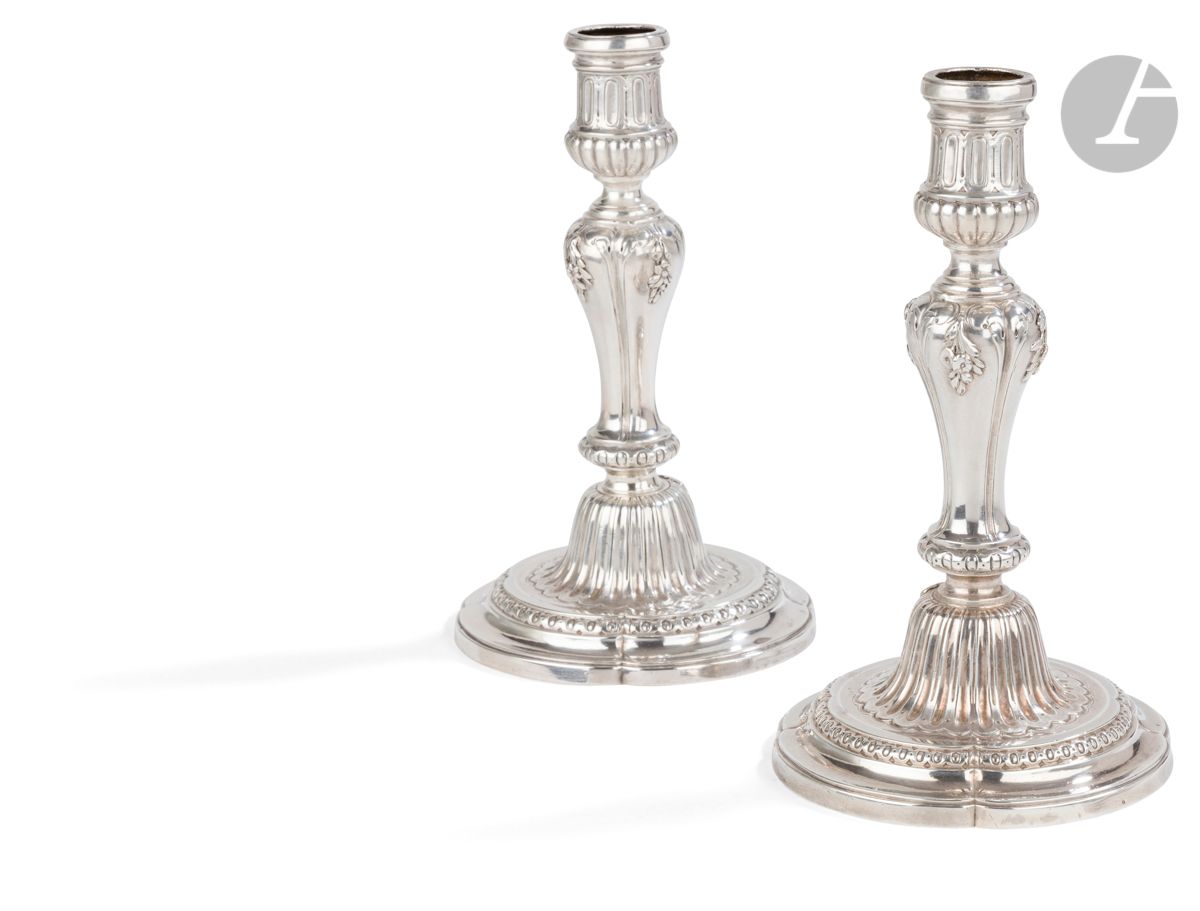 PARIS 1781 - 1782
Paire de bougeoirs de voyage en argent, le fût se vissant dans l’ombilic. La base ronde à contours se prolonge par un rang d’oves, l’ombilic à canaux en rappel sur le binet reçoit un médaillon perlé gravé d’un monogramme SC postérieur. Le fût à quatre pans est agrémenté de fleurs et feuilles en chute dans sa partie haute. 
Maître orfèvre : Joseph-Théodore VAN CAUWENBERGH ou VANCOMBERT , reçu en 1770
Poids : 772 g - hauteur : 20 cm - diamètre de la base : 11,5 cm