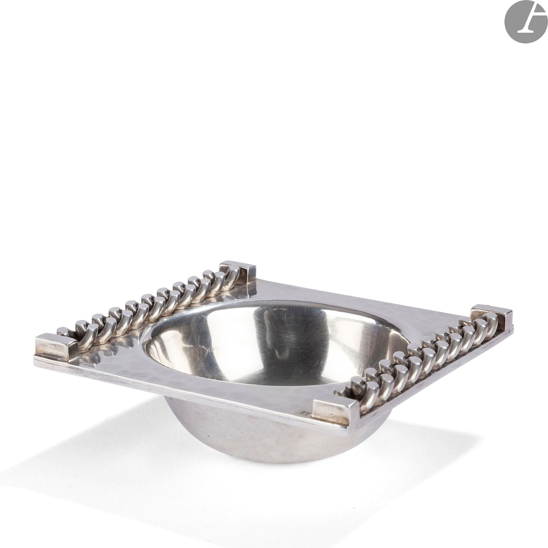 JEAN DESPRÈS (1889-1980
)
BraceletSquare
ashtray
in silver plated metal. The perimeter treated hammered receives a curb chain with flat links and in application on each side part. The bowl treated smooth. Signed J. DESPRÈS at the point on the reverse and bears the hallmark of Master Goldsmith. H. 3 cm - L. 9,5 cm


