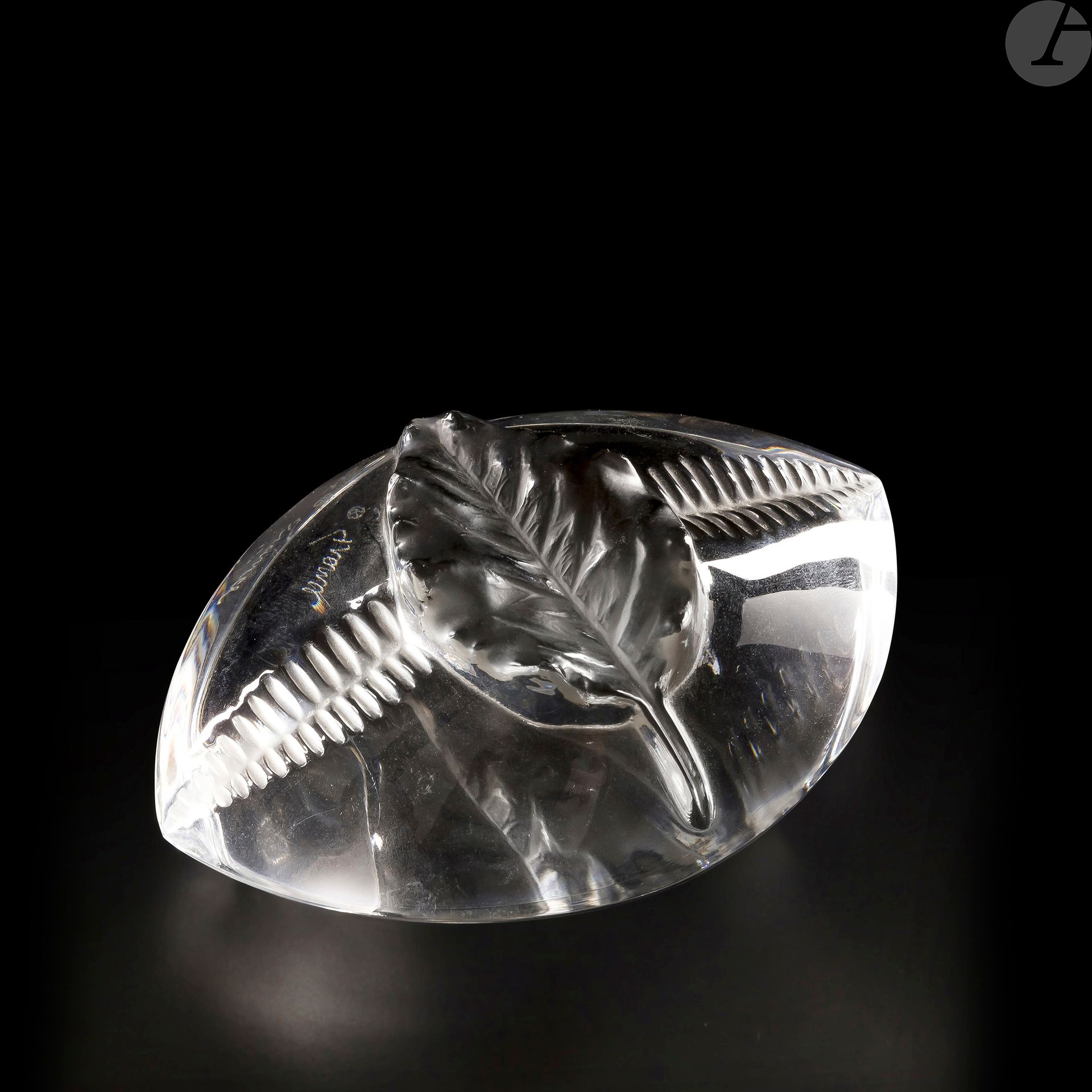 MAISON LALIQUE
Feuille et fougère
Presse-papier ovoïde. Épreuve en cristal moulé-pressé et, en partie, satiné. Signé LALIQUE France à la pointe sous la base. L. 11 cm