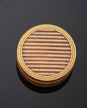 FRANCE FIN XVIIIe siècle
Tabatière circulaire en écaille blonde montée en or (18 Kt), l’écaille rehaussée de bandes d’or sur l’ensemble délimitées par des cerclages d’or.
Poinçonnée deux fois d’une garantie (illisible) - probablement au hibou - 
Poids brut : 37 g - diamètre : 5,5 cm - 
hauteur : 2,2 cm