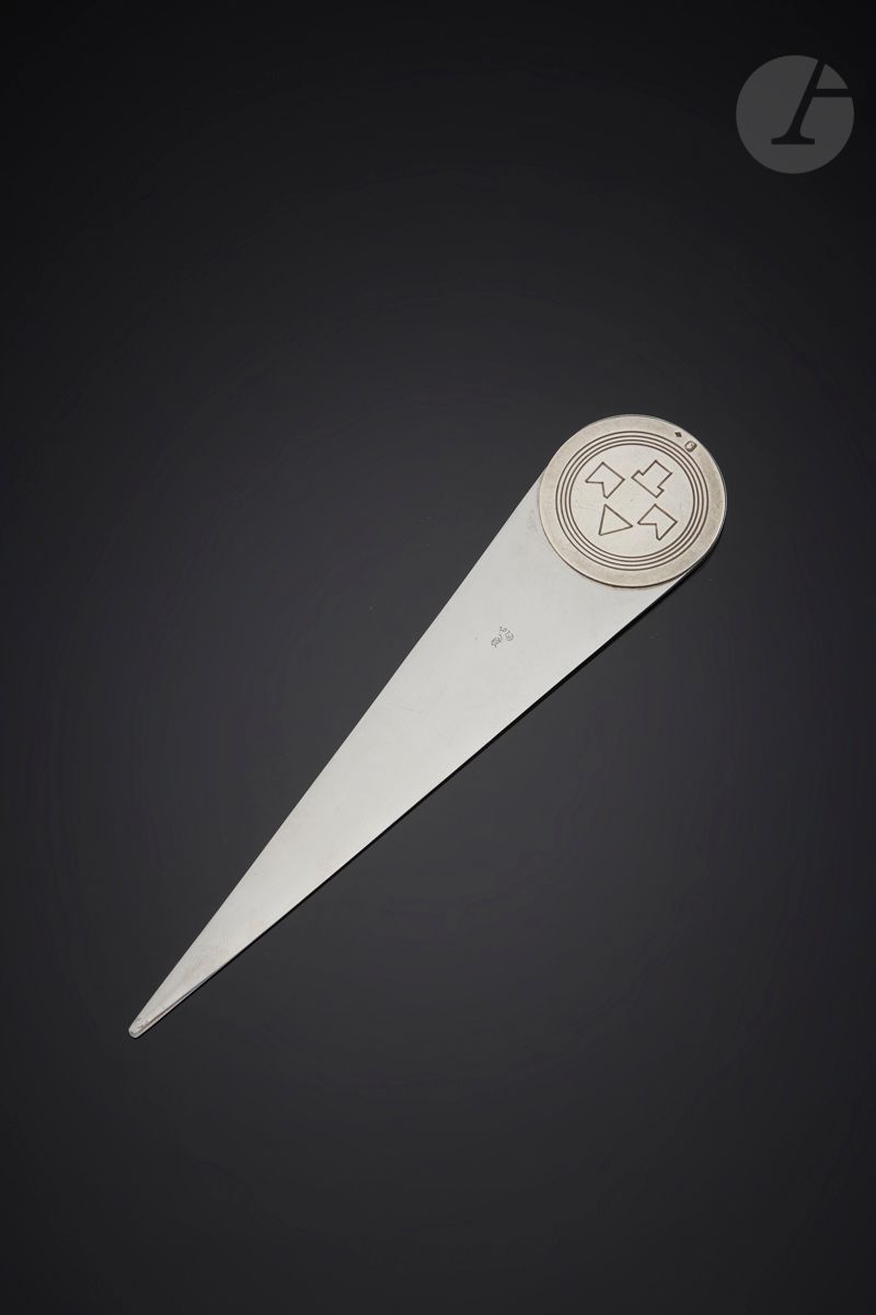 FRANCE CIRCA 1930
Coupe papier / ouvre lettre en acier inoxydable opposant le mat de l’argent et le brillant de l’acier. La lame est marquée ELOI et au revers « déposé » dans un cercle. La prise circulaire en argent est gravée de quatre rangs de filets et sur une face des lettres majuscules MMT en typographie Art déco.
Poinçon minerve
Orfèvre : Charles Louis Éloi PERNET (poinçon losangique)
Poids brut : 65 g - longueur : 18 cm