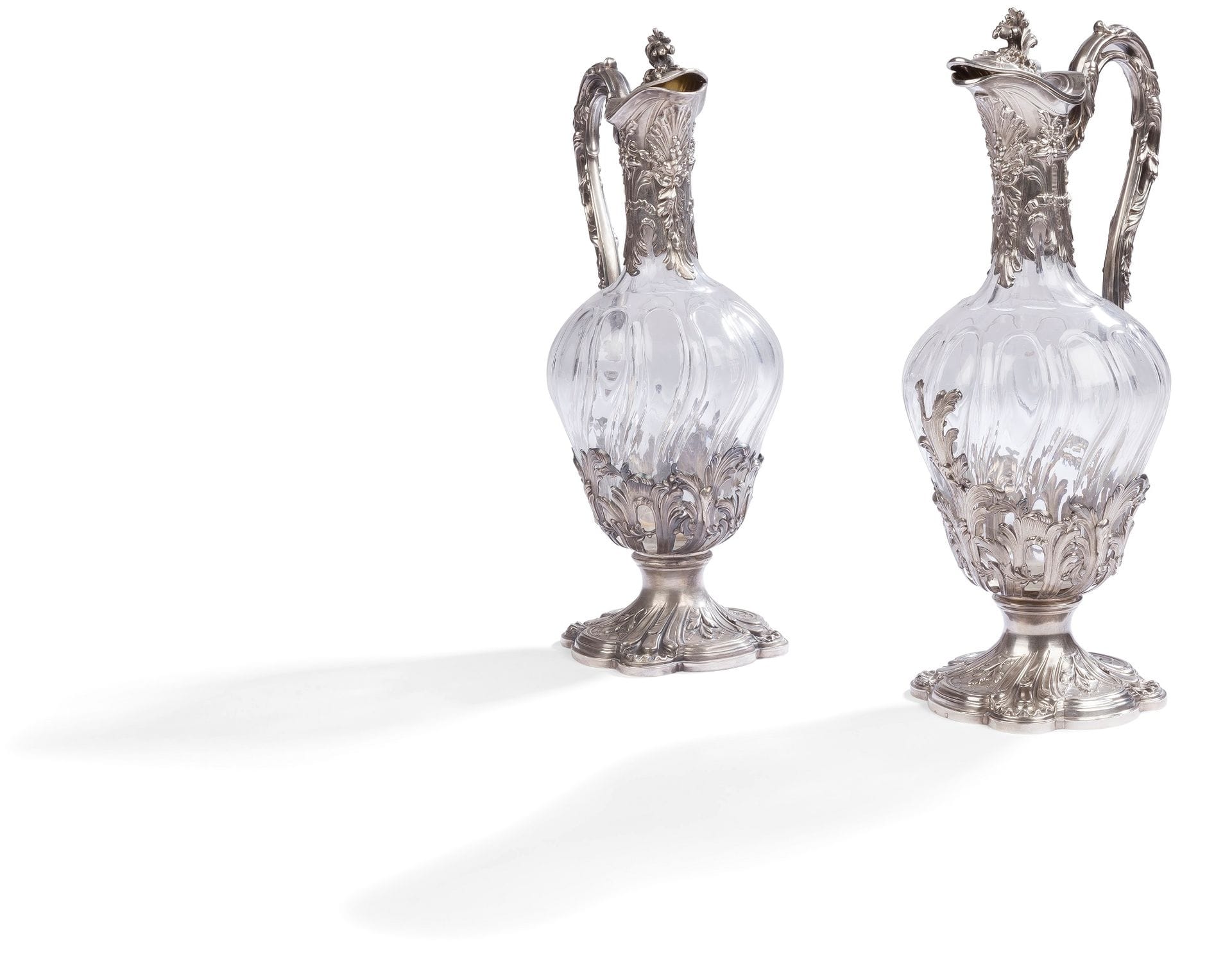 FRANCE DEUXIÈME MOITIÉ DU XIXe SIÈCLE
Paire d’aiguières couvertes en argent, l’intérieur en vermeil, le corps en cristal taillé de côtes torses se prolongeant sur le col. La monture en argent de style rocaille ajouré, sommée d’une prise feuillagée.
Orfèvre : Edmond TÉTARD, 1860 - 1901
Poids brut : 2184 g - hauteur : 30,5 cm
État : cristal en parfait état, la monture avec accidents et manques.