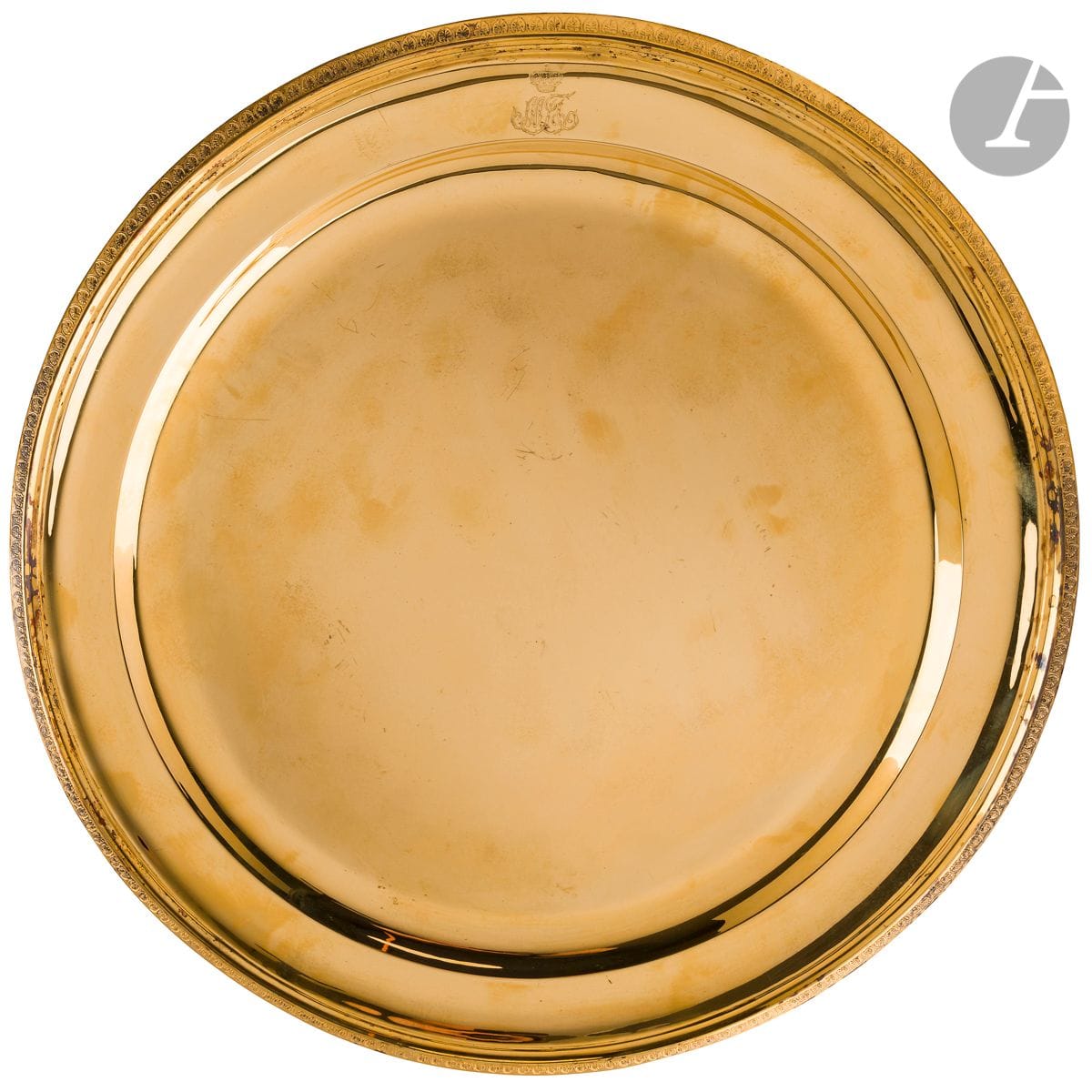 PARIS CIRCA 1840 
Grand plat en vermeil de forme ronde, la bordure rehausssé d’un décor à la molette de palmettes. Le marli gravé du monogramme du Grand Duc MICHEL PAVLOVITCH de Russie.
Poids : 1861 g - diamètre : 41 cm
Poinçons de BIENNAIS, en toutes lettres pour Martin-Guillaume BIENNAIS
État : repoli, redoré
Exécuté après 1840 en complément du service Pavlovitch, sans garantie pour les poinçons.
