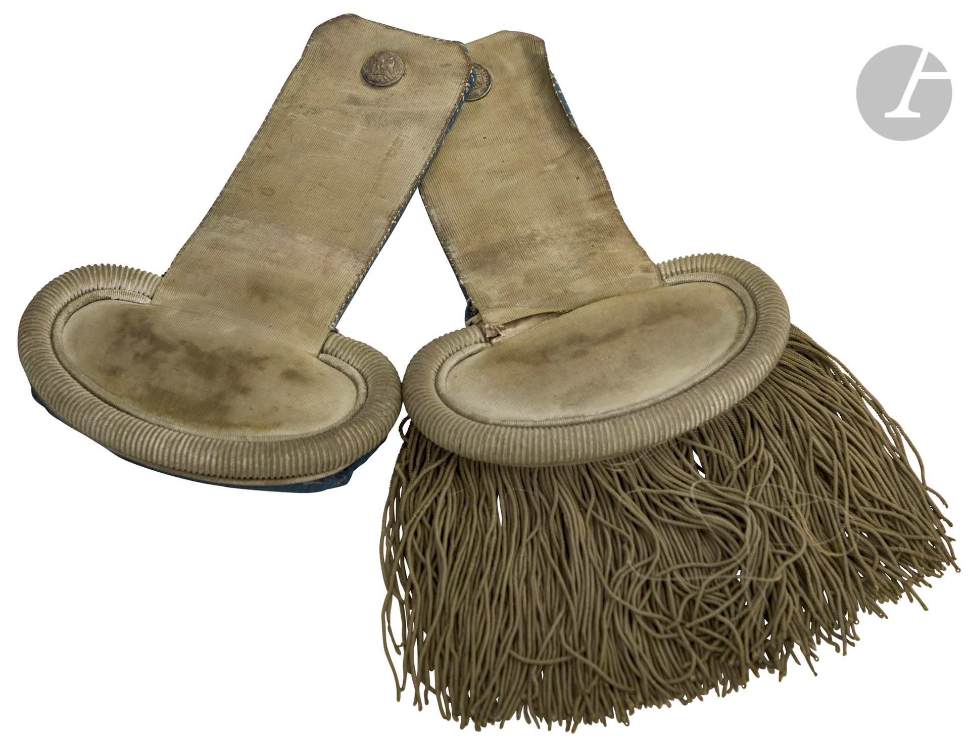 Paire d’épaulettes contre épaulettes d’officier de la Garde impériale. 
Corps et franges en passementerie argentée. Doublure en drap bleu ciel
Boutons en laiton argenté à l’Aigle marqués « GARDE IMPERIALE ». Crochets marqués du fabricant « FAUQUET » 11 rue de Turbigo. 
A.B.E. (Trous à la doublure, en partie décousue). Époque Second Empire.