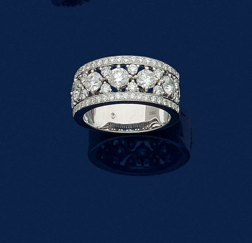 Bague bandeau en or gris 18K (750), sertie d’une ligne de 5 diamants ronds de taille brillant scandés et encadrés de diamants de taille brillant plus petits. Travail français du début du XXIe siècle. Tour de doigt : 54. Poids brut : 8,3 g

A French ring set with diamonds