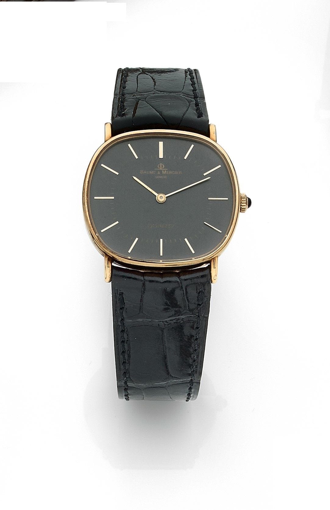 BAUME & MERCIER. Vers 1970
N° 1041656
Montre bracelet d’homme en or 18K (750), cadran noir, index bâtons appliqués formant les heures, mouvement à quartz (fonctionne), bracelet cuir avec sa boucle ardillon en métal doré signée.
Cadran, boîtier et mouvement signés.
Dimensions : 31 mm x 32 mm 
Poids brut : 31,8 g
