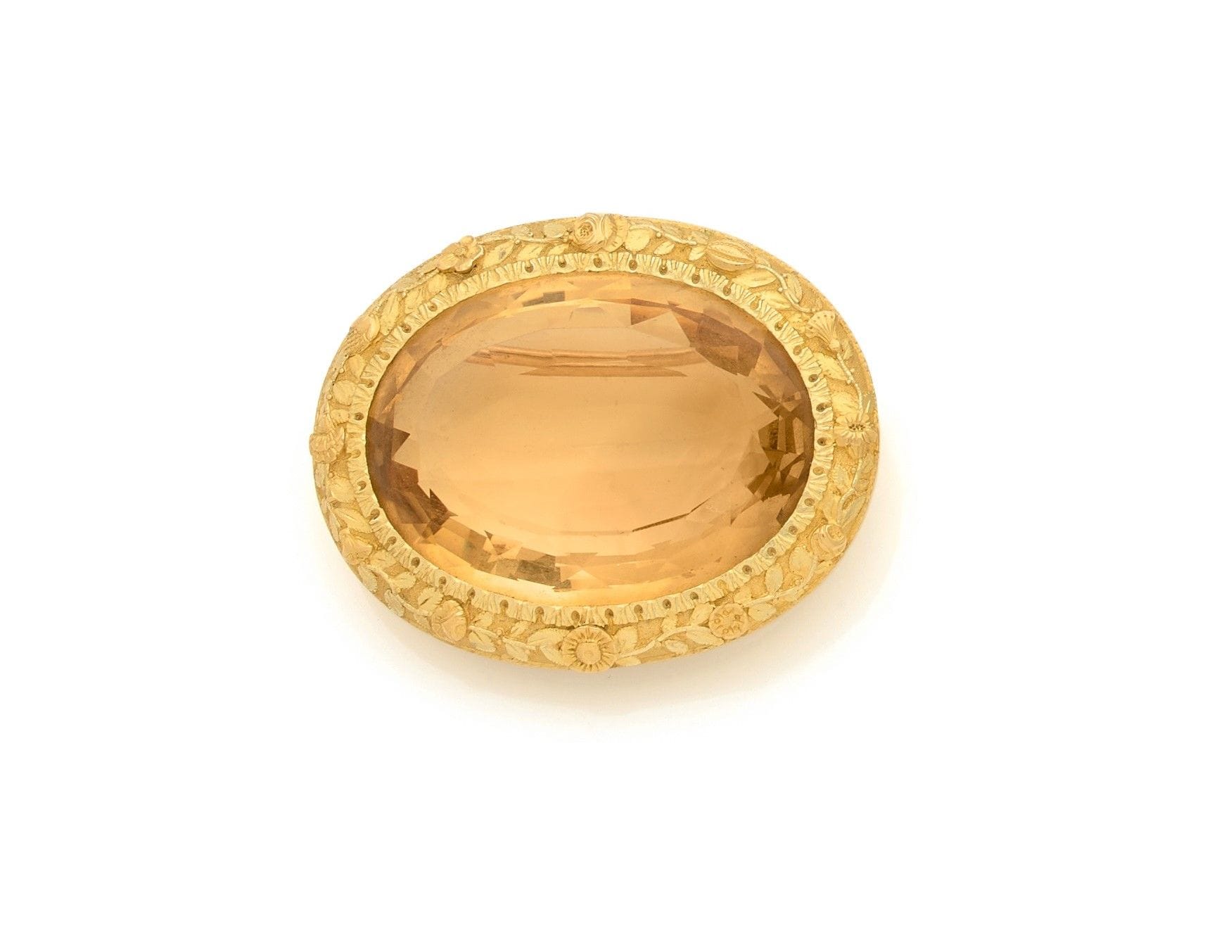 Broche ovale en or 18K (750), sertie d’une importante citrine, la monture gravée de fleurs et de feuillages. Travail de la seconde moitié du XIXe siècle. Dimensions : 4,7 x 3,7 cm environ. Poids brut : 40,8 g 

A 19th century brooch set with a citrine
