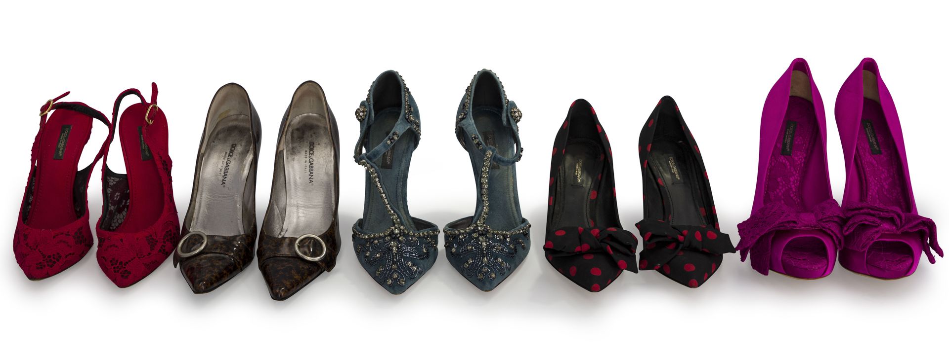 Dolce & Gabanna. Lot de 5 paires d'escarpins (usures, en l'état), T. 37 et 37,5 1 : 1 en cuir verni marron et noir, 1 satinée fushia, 1 en tissu noir et pois rouges, 1 en dentelle rouge et 1 en velours bleu gris appliqué de strass et broderies.