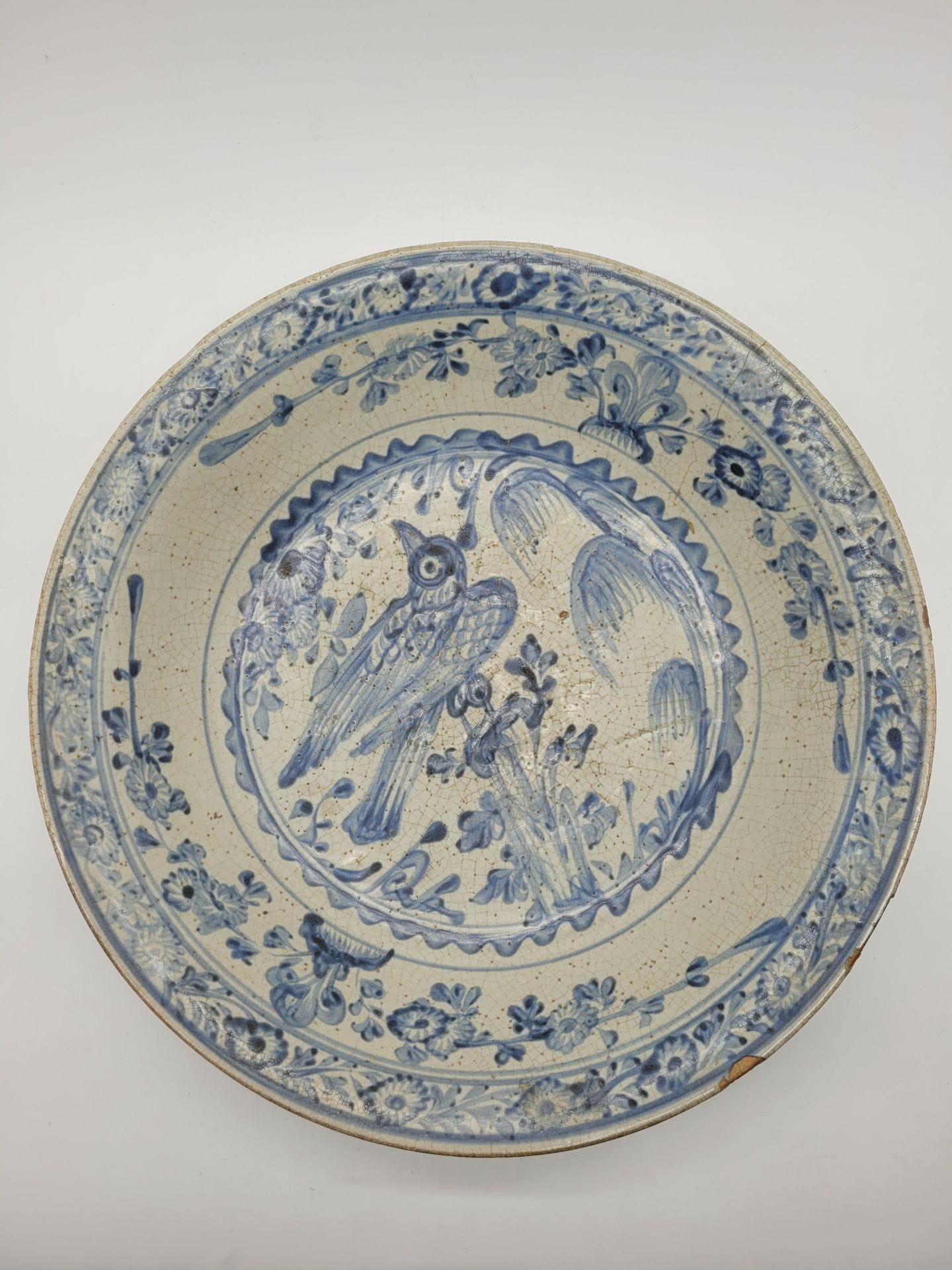 Round blue-white porcelain dish, China, Swatow (Zhangzhou) kilns, Wanli period (1573-1620
)With central decoration of a bird perched on a rock, frieze of flowering branches in reserve.
Diameter : 41,4 cmCracks
, chips, enamel skip.


