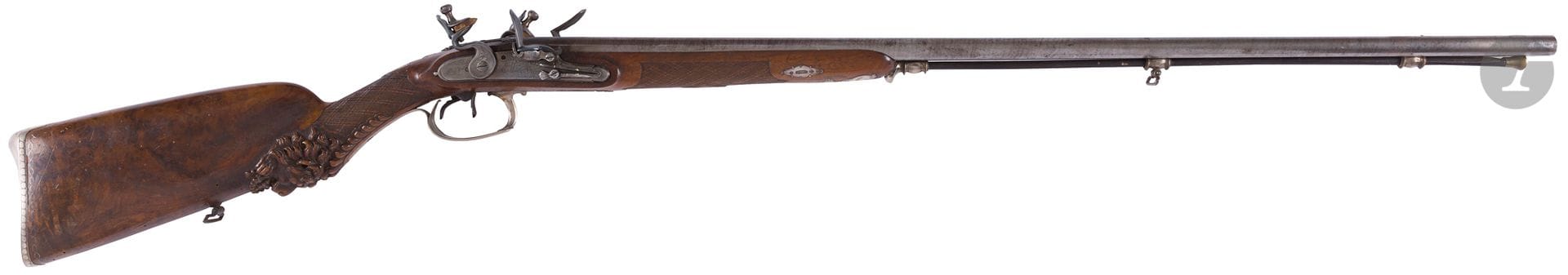 
Double flintlock shotgun with the arms of the Sars du Catelet family. {CR}Barrels in table, ribbons damas. Steel breechblock engraved with friezes and flowers. Lock with remains of signatures. {CR}Beautiful engraved silver fittings with flowering baskets and foliage.  {CR}Bridge plate engraved with large Duke's arms. Bedplate with frieze decoration. {CR}Walnut crook with pearled cheek carved with lion's head, wickerwork grid, decorated with silver wire inlays. Rod in dewlap. {CR}Title cock 2, head of old man (2nd title and big guarantee, Province 1798-1809) and of goldsmith "LD"{CR}Overall length: 125 cm - Barrel length: 84 cm{CR}A.B.E. (Flintlock). Circa 1800. {CR}{CR}Original of Cambrai, the arms of the Sars du Catelet family are as follows "Tiercé in pale: in I, azure, with the silver lion, in 2, gules, with the silver eagle in chief, and with the cross potentate of the same in point; in 3, or, with three bars azure." {CR}{CR}We thank Mr. Alban Pérès for his help in identifying the coat of arms.

Note: The condition of the arms in M.A.'s collection is given as an indication, many arms having undergone modifications, repairs and restorations.

 

 We have noted the main oneś. They are sold in the state
