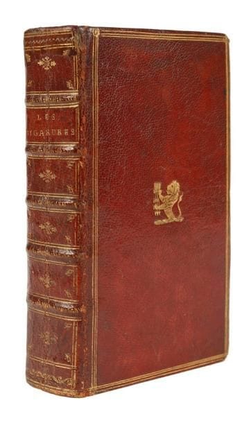 [TABOUROT (Étienne)]
Les Bigarrures et touches du seigneur des Accords, avec les apophtegmes du sieur Gaulard. Et les escraignes dijonnoises. Paris: Arnould Cotinet, Étienne Maucroy, 1662.{CR}. 4 parties en un volume in-12, (12 ff.), 514 pp., (1 f. bl.); (1 f.), 262 pp., (1 f.) - Maroquin rouge, triple filet doré en encadrement sur les plats, armes dorées au centre du premier plat, dos à nerfs orné, roulette dorée intérieure, tranches dorées sur marbrure (reliure de l'époque). Édition définitive, la plus recherchée, de ce célèbre livre facétieux du poète dijonnais Étienne Tabourot, sieur des Accords (1547-1590). L'ouvrage constitue un témoignage de première importance sur les pratiques poétiques au XVIe siècle; il contient des rébus, contrepèteries, calembours, anagrammes et autres vers rétrogrades, ainsi que des récits populaires parfois grivois dont "les escraignes dijonnoises" constituées de 50 contes truffés de paillardises fidèles à l'esprit gaulois. Il s'agit également du premier ouvrage à proposer un article sur la contrepèterie et le premier à faire référence à ce terme (chapitre VIII pages 145 à 154). À la fin figure, avec un titre propre, les contes facétieux du sieur Gaulard. L'édition est illustrée d'un portrait de Tabourot à l'âge de 35 ans, gravé sur bois et répété 3 fois, d'un portrait du sieur Gaulard d'après Nicolas Hoey et de plusieurs figures gravées sur bois dans le texte pour les rébus de Picardie et les "Autres sortes de rébus". Chacune des quatre parties possède un titre particulier, la seconde et la troisième sont ici à l'adresse d'Étienne Maucroy. Exemplaire portant sur le premier plat les pièces d'armes de Gramont d'Aster, constituées du Lion (Gramont) et des trois flèches pointes en bas (Aster). De la collection également du journaliste Benoît Jouvin (1810-1886), rédacteur en chef du Figaro, avec ex-libris gravé par Stern, et ex-libris "F. R.de Brem". Coins légèrement émoussés et quelques minimes frottements. Habile restauration en coiffe de tête. Quelques feu