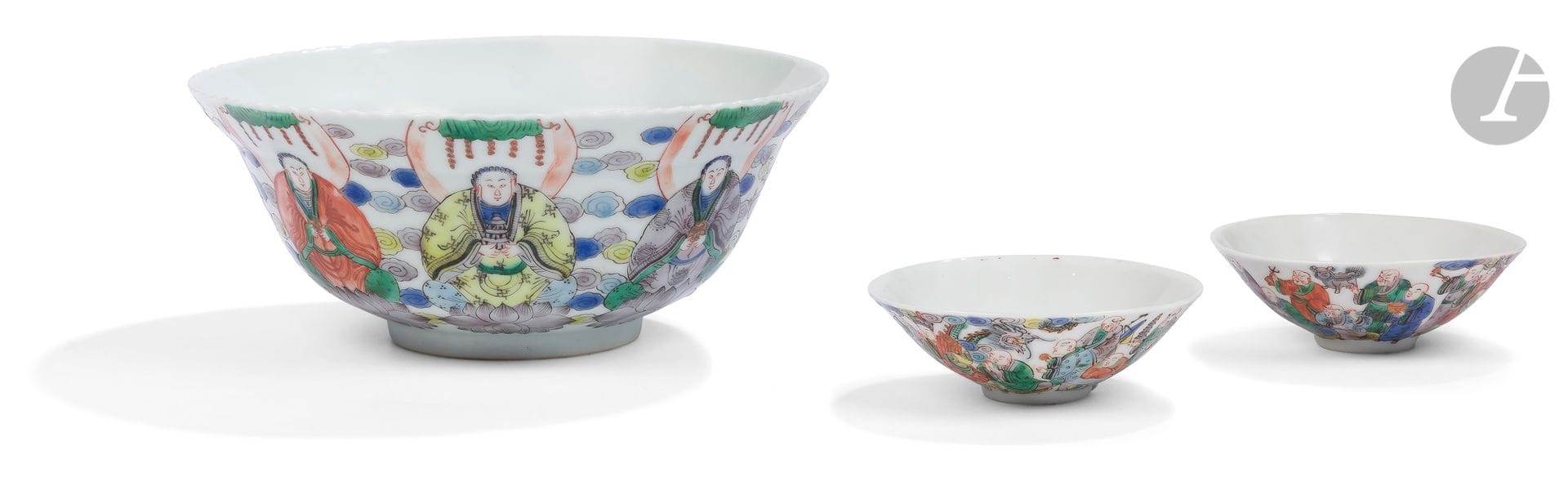 Trois bols en porcelaine dans le style de la famille verte, Chine, milieu du XXe siècle
Deux à bord évasé à décor des dix-huit Lohan avec leurs attributs. Le troisième à décor des quatres Rois Célestes debout sur des feuilles de lotus, d’un bodhisattva et de trois représentations du panthéon bouddhique, assis sur des socles en forme de fleur de lotus. Un bonze assis tenant un chapelet au fond de chaque bol. Marque à quatre caractères en rouge de fer 大雄寶殿 - da xiong bao dian - « salle précieuse du grand héros » ou « salle de la grande force » à la base, entourée de deux dragons à la poursuite de la perle sacrée.
Diamètre : de 9,7 à 20 cm
Accidents, fêles, égrenures.

La marque 大雄寶殿 - da xiong bao dian est utilisée dans les temples bouddhistes chinois traditionnels pour nommer la salle Mahavira, connue aussi sous le nom de « salle principale », consacrant des représentations du bouddha Shakyamuni et de divers autres bouddhas et bodhisattvas.

二十世纪中期
素三彩佛教主题瓷碗一组三件