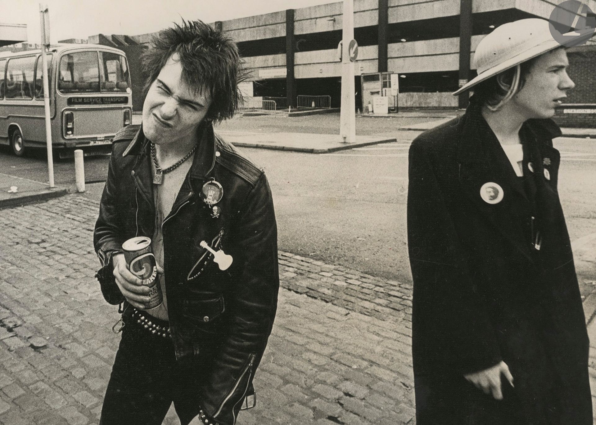 Barry Plummer - Dennis Morris 
Sex Pistols. c. 1975-1980. 
Kohnny Rotten sur une croix. Gare routière.
Deux (2) épreuves argentiques d'époque. Tampons des photographes et annotations manuscrites aux versos. 
Format moyen : 20 x 25 cm 

Barry Plummer - Dennis Morris 
Sex Pistols. c. 1975-1980. 
Kohnny Rotten on a cross. Bus station.
Two vintage gelatin silver prints. Photographers's stamp and handwritten annotations on versos. 
Average size : 20 x 25 cm