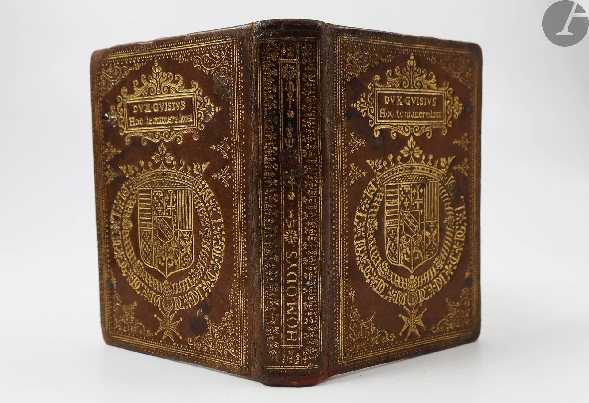 HOMÈRE.
ΟMHPOY  ΟΔΥΣΣEIA, Homeri Odyssea; id est de rebus ab Ulysse gestis. Unà cum Batrochomyomachia, Hymnis, & Epigrammatis.
[Genève] : Jean Vignon, 1609. — In-16, maroquin havane, roulette dorée en encadrement, fers dorés aux angles, et armes dorées surmontées d'un cartouche doré avec mention « Dux Guisius Hoc te munere donat » sur les plats, dos lisse orné (reliure de l'époque).

Rare édition entièrement imprimée en grec, de l' « Odyssée » d'Homère. Vignon en donna la même année une édition gréco-latine, accompagnée de « L'Iliade », que l'on rencontre plus souvent.

Preuve de sa rareté, aucun exemplaire n'est répertorié dans les bibliothèques publiques françaises et étrangères (voir WorldCat).

EXEMPLAIRE DE PRIX, AUX ARMES DU DUC DE GUISE.

Selon Olivier, Hermal et Roton (Pl.50), ces armes sont celles d'Henri de Lorraine, 3e duc de Guise, dit le Balafré, assassiné au château de Blois sur ordre d'Henri III en 1588. Surmontées d'un cartouche portant l'inscription : « Dux Guisius Hoc te munere donat », elles ornaient des livres de prix attribués en vertu d'une fondation.

On connaît au moins quatre autres reliures portant ces armes accompagnées du cartouche, toutes recouvrant des livres publiés après la mort du duc de Guise. L'une est conservée à la Bibliothèque nationale de France, sur un Pline (Genève, 1611), une seconde recouvre un Cicéron, également édité à Genève chez Jean Vignon, en 1617 (vente J.-Ch. Brunet, II, 1868, n°532), une troisième sur un Sénèque de 1604, paru aussi chez Jean Vignon (vente Binoche et Giquello, 9 décembre 2013, n° 196) et une quatrième recouvrant une édition des œuvres de Stace publiée à Leyde en 1616 (Bibliothèque générale du Lycée de Toulon, D. 2509, citée par OHR, pl. 50 verso).

Manque les liens. Coins et coiffe inférieure restaurés, accrocs au dos, sans les gardes. Déchirures avec manques au titre, sans atteinte au texte, gribouillage ancien à l'encre au verso du feuillet *8, rousseurs. Il manque le dernier feuillet.

Provenance : oratorien de Toulouse, avec mention manuscrite « Oratorii Tolosani » sur le titre (XVIIe siècle). - Maison d'institution de l'Oratoire, avec cachet sur le titre. - Maison Perreyve, Fribourg, avec cachet sur le premier contreplat.