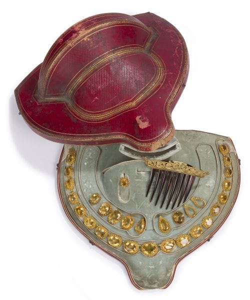 Collier en or 18K (750), articulé de maillons ovales en chute, sertis de citrines, la monture soulignée de canetille. Travail français, poinçon pour Paris 1819-1838. Conservée dans son écrin à la forme gainée de velour vert d'eau. Longueur : 42 cm environ. Poids brut : 96,6 g (on joint un peigne en écaille monté en métal, des montures de boucle d'oreille et de pampilles en or 18K, ainsi que 8 citrines ovales ou taillées en gouttes ; accidents, égrisures)