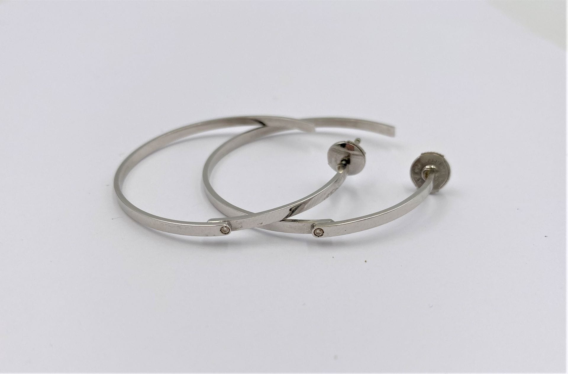DINH VAN 

Paire de créoles en or gris 18K (750), chacune sertie d'un diamant rond de taille brillant. Signées. Diamètre : 4,3 cm environ. Poids brut : 8,5 g