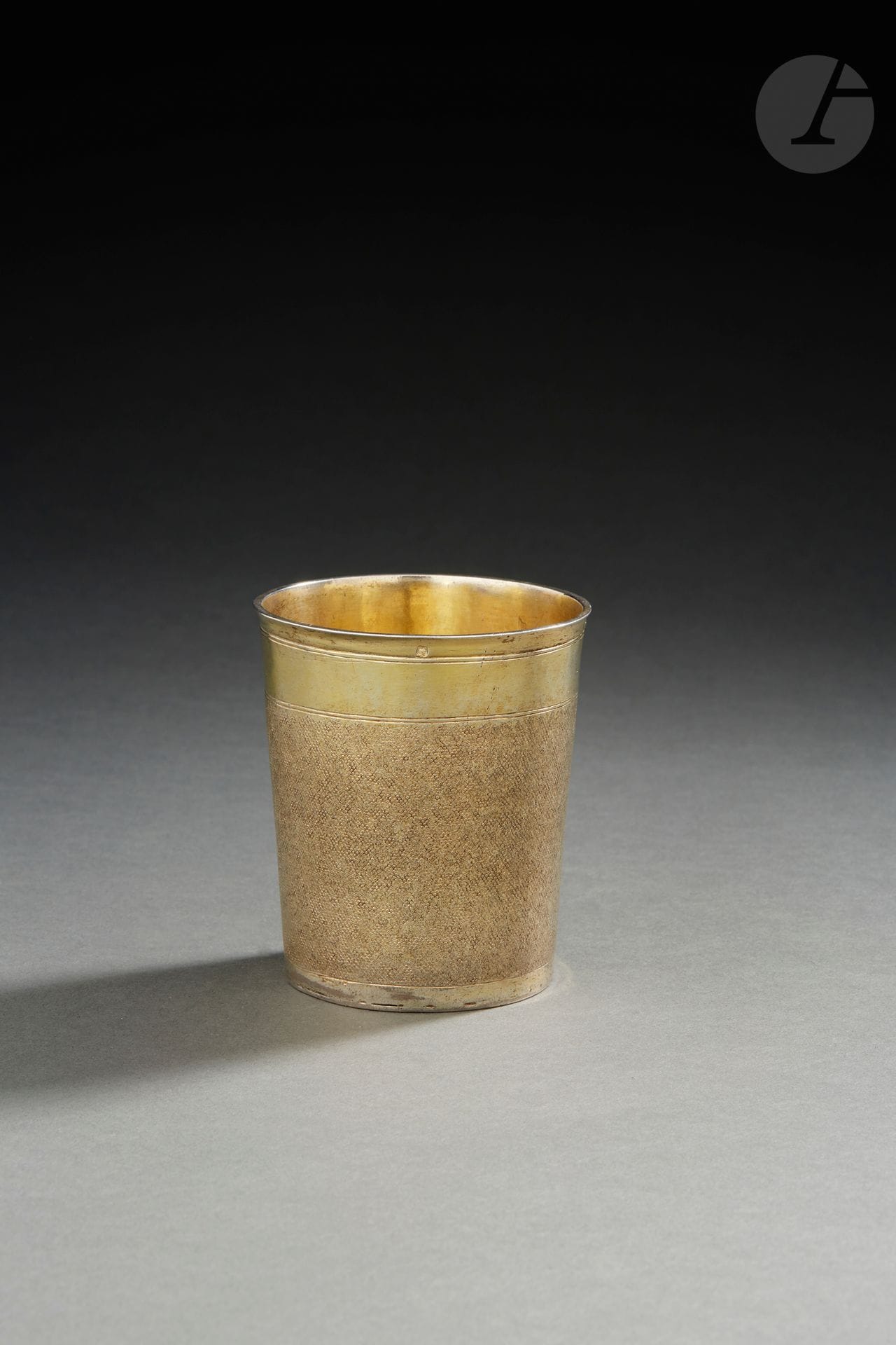 STRASBOURG 1700 - 1720
Timbale en vermeil de forme légèrement évasée à décor dit « peau de requin » entre deux bandeaux unis.
Maître orfèvre : Daniel KAUFMANN, établi à BARR ou à HEILLIGENSTEIN, reçu en 1682
Poinçon de contrôle à la minerve deuxième titre sous la bordure
Poids : 137 g - hauteur : 8,7 cm