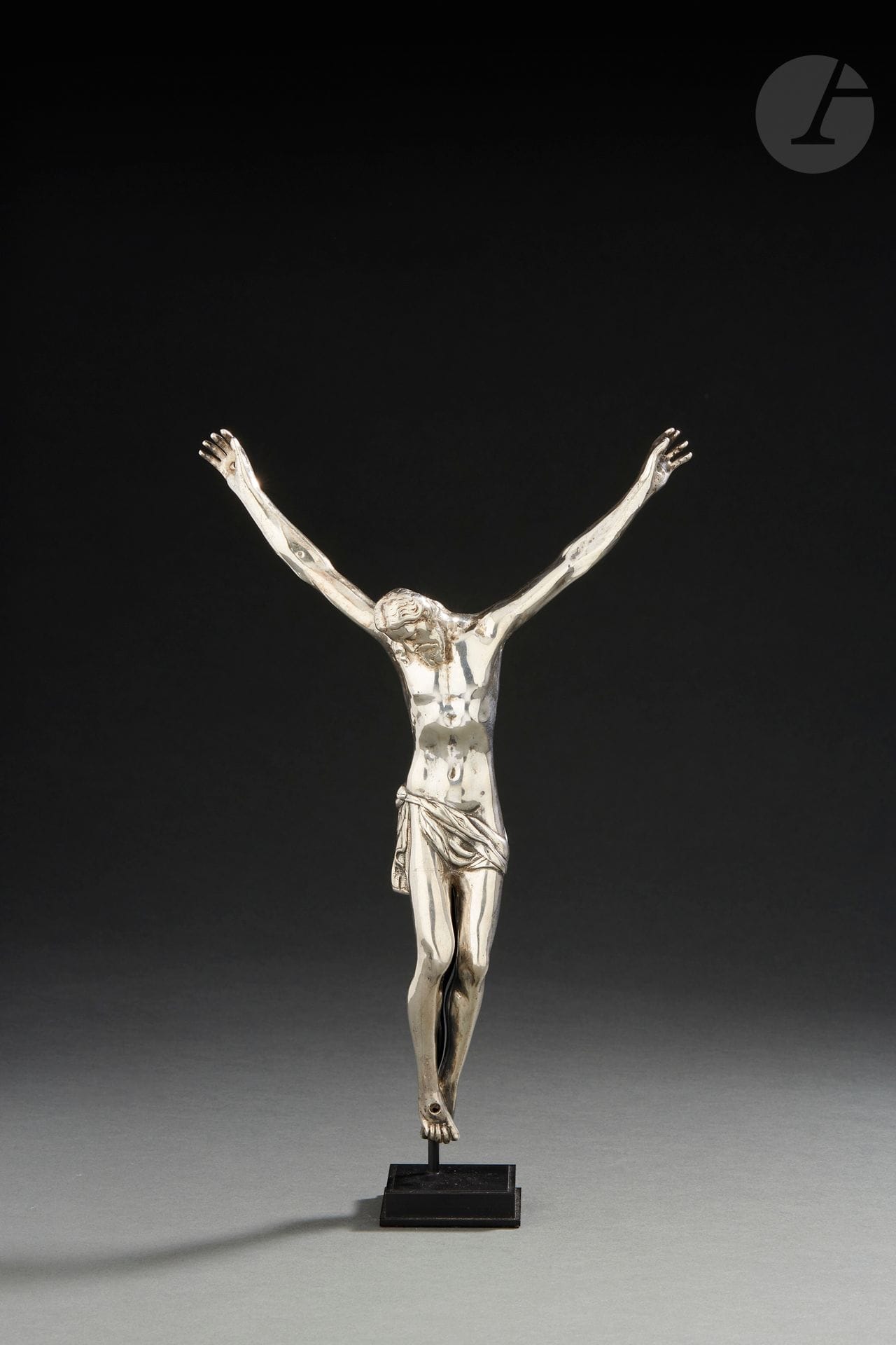LILLE FIN DU XVIIe SIÈCLE OU DÉBUT DU XVIIIe SIÈCLE
Christ en argent fondu et ciselé. La tête penchée sur l’épaule droite, le pied droit est posé sur le gauche et le périzonium noué sur la hanche droite. Empreintes des clous dans les mains et sur les pieds.
Maître orfèvre : Robert de NOVELLES actif en 1678, décédé en 1724
Poids : 330 g - hauteur : 25 cm