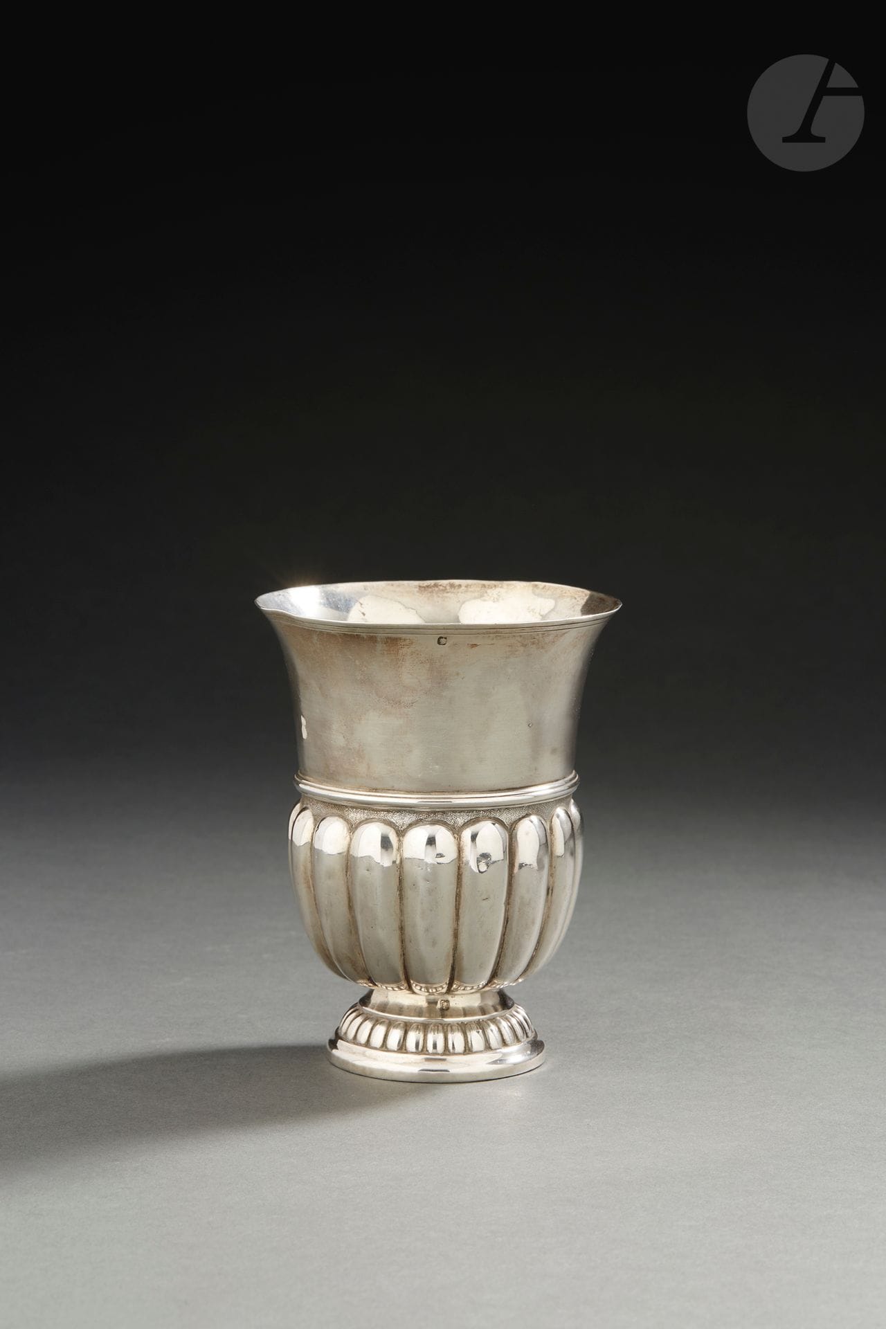 NORD OU EST DE LA FRANCE
Timbale tulipe en argent. Le piédouche est repoussé de godrons en rappel aux deux tiers du corps séparé par un large jonc de filets.
Maître orfèvre non identifié 
Poids : 179 g - hauteur : 11,6 cm
Poinçons : repoinçonnée à la minerve en bordure du col
État : repolie sous la bordure