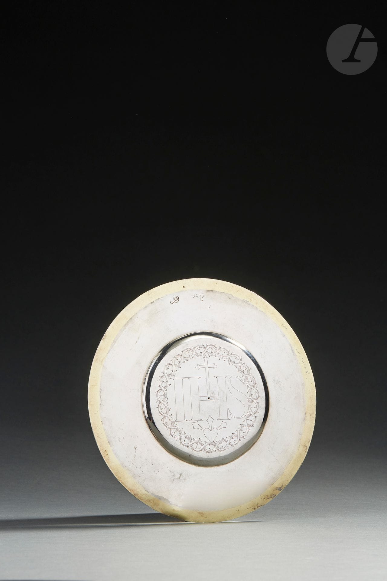 PARIS 1671 - 1672
Patène en argent et vermeil, la partie centrale présente une légère doucine au centre de laquelle est gravée une couronne d’épines entourant le monogramme IHS.
Maître orfèvre : Nicolas LEVEQUE, reçu en 1667
Poids : 166 g - diamètre : 17,4 cm