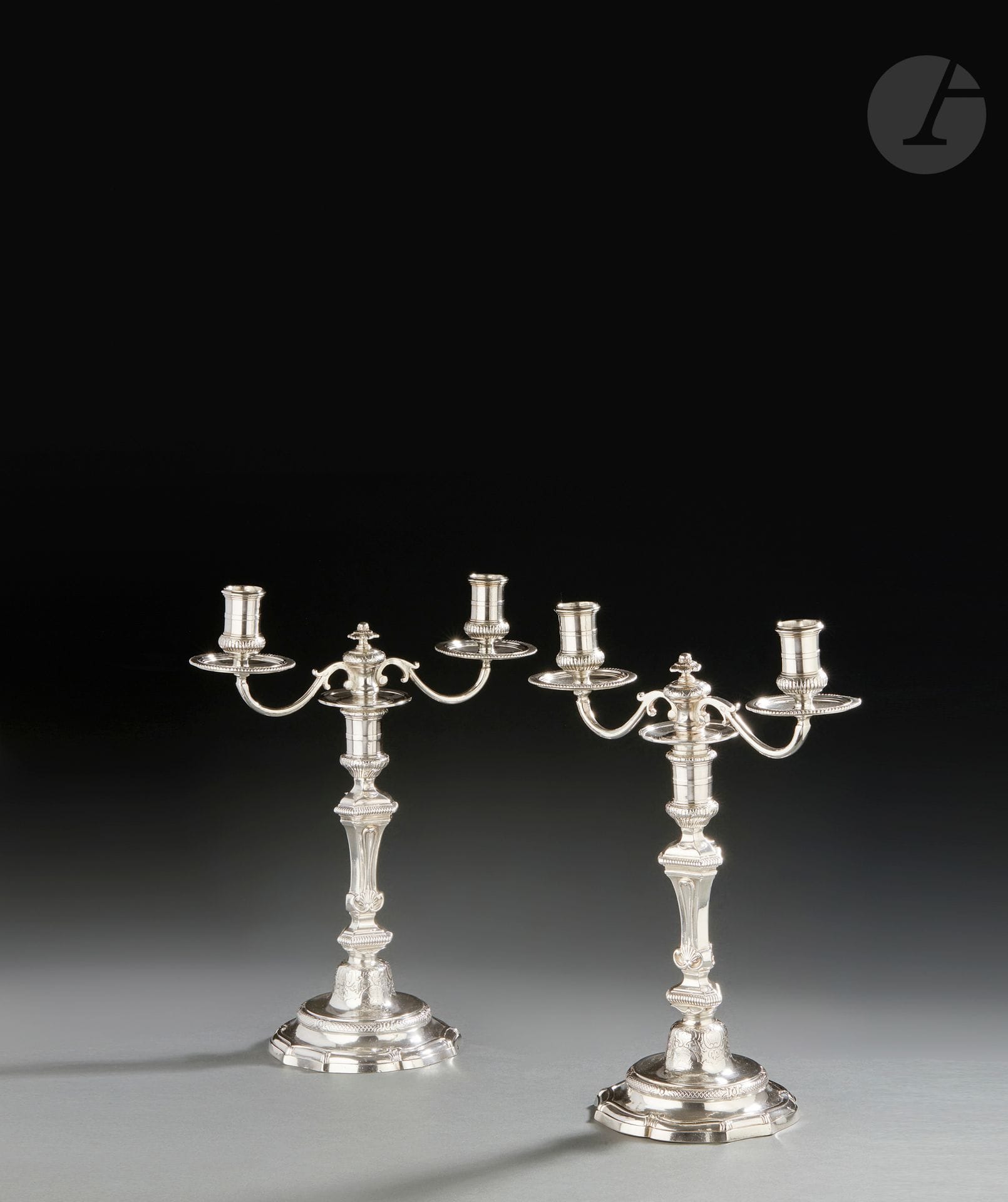 RENNES 1750 - 1752 et 1739 - 1750 POUR LES BRAS DE LUMIÈRE
Paire de bougeoirs en argent et des bras à deux lumières. La base à contours est prolongée d’un bandeau plat et d’agrafes. La partie haute de l’ombilic est gravée ciselée sur fond amati de volutes et de fleurons entourant partiellement une gravure d’armoiries sommées d’une couronne de marquis. Le fût balustre, à trois pans et coquille accompagné à chaque niveau de godrons en rappel sur les bras de lumière. Ces derniers à enroulements symétriques sont agrémentés au centre d’une fleur et de feuilles lancéolées.
Maître orfèvre : Michel Eloy LE TAILLEUR, reçu en 1739
Poids : 2373 g - hauteur : 33 cm