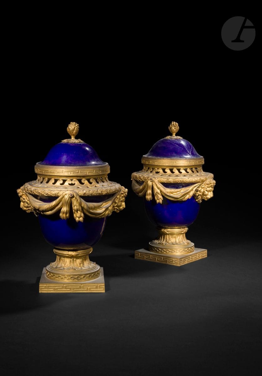 Paire de vases pot-pourri Dulac en porcelaine bleu à monture de bronze doré à décor de mufles de lion, frise de postes ajourée et guirlandes de feuilles de laurier ; (accidents et restaurations, notamment à la porcelaine d’un des couvercles).
Style Louis XVI, XIXe siècle.
H. : 44 cm
